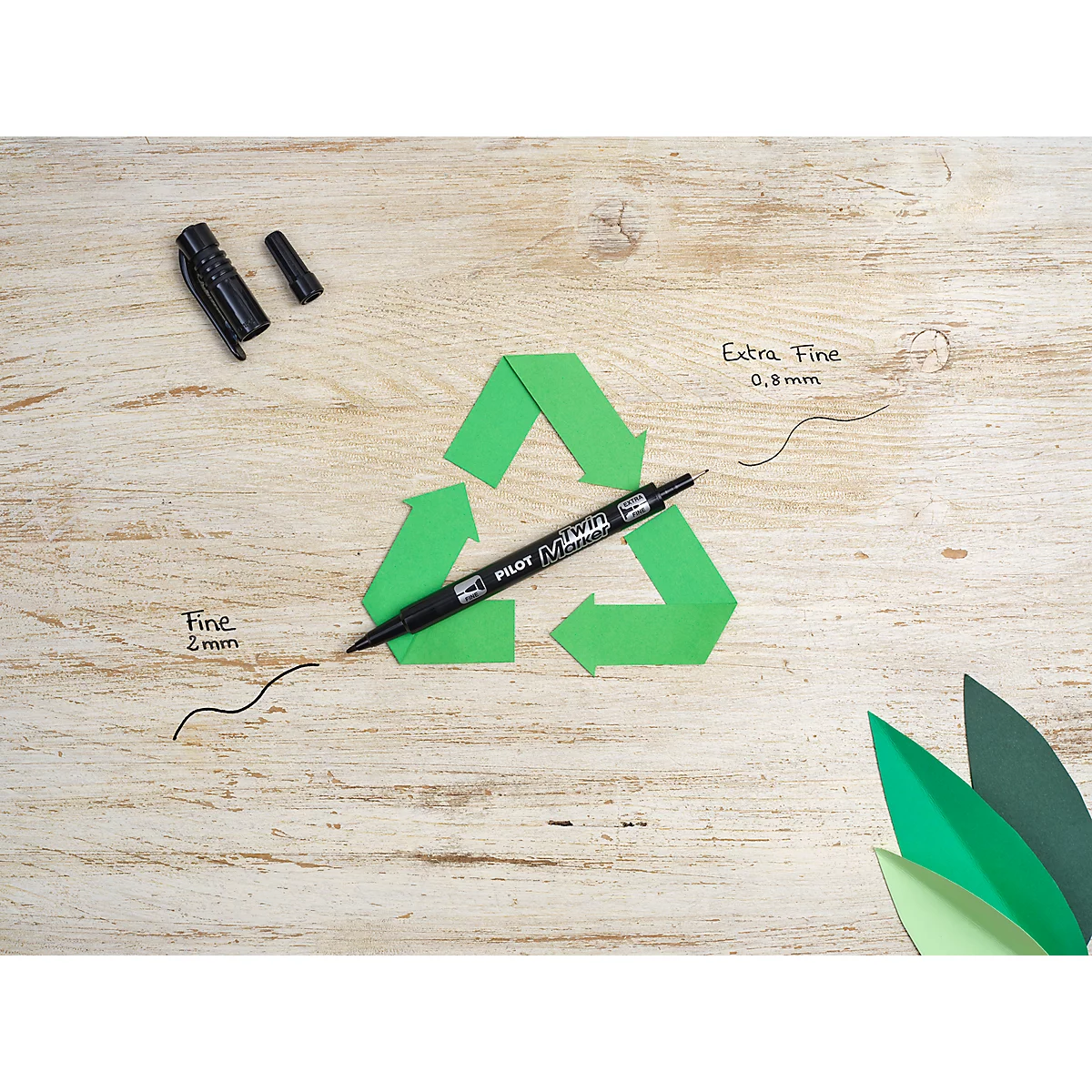Un stylo noir Pilot posé sur un symbole de recyclage sur un fond en bois clair.