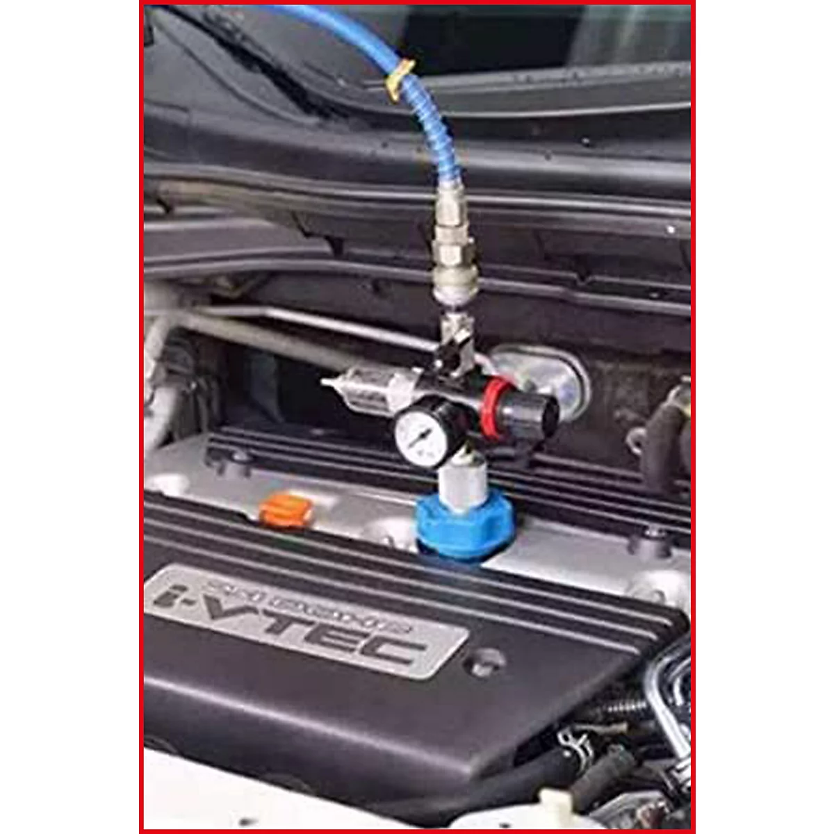 Nahaufnahme des Motorraums mit einem Werkzeug. Blaue Leitung, Messgerät und schwarzer Motor. Aufschrift: I-VTEC.