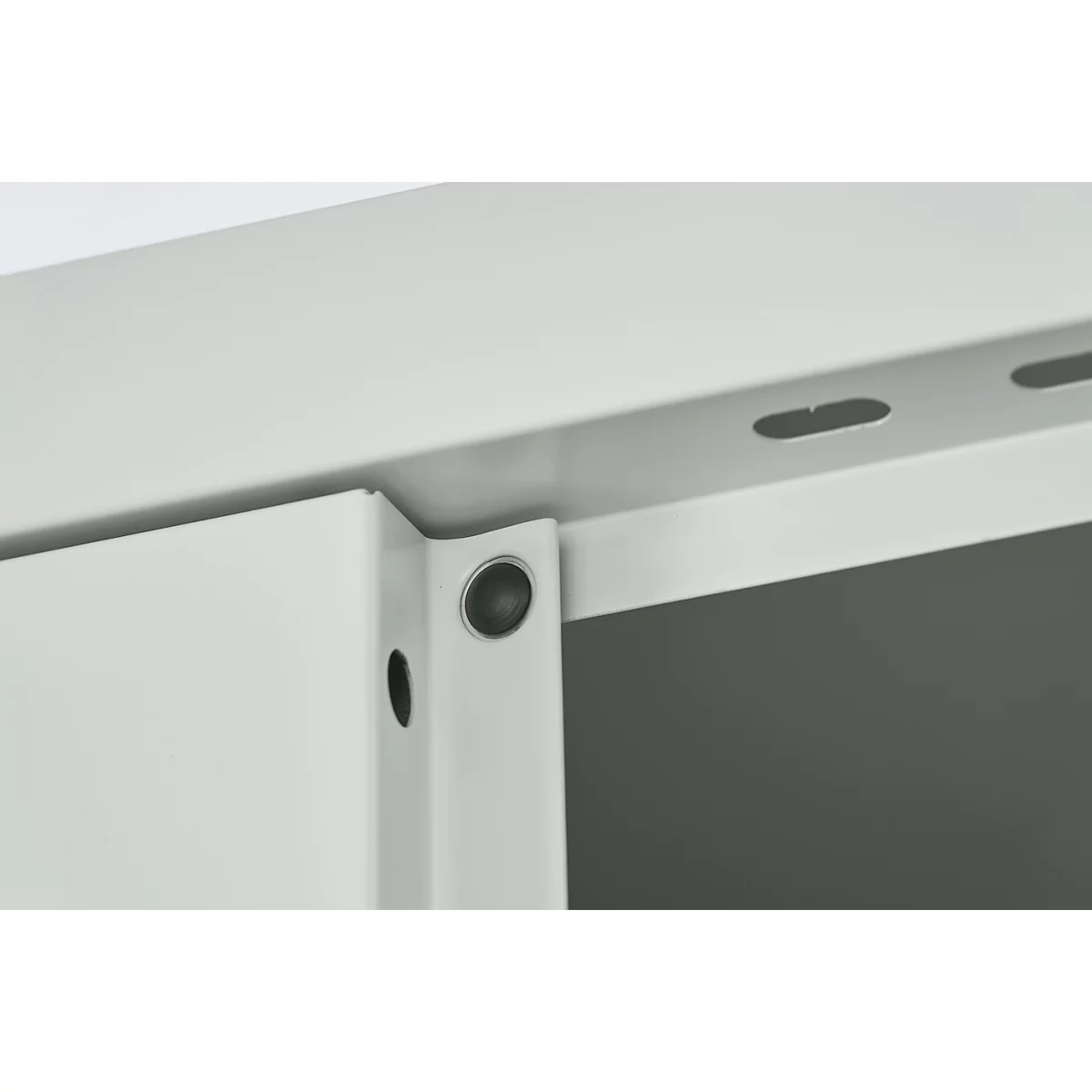 Detailopname van een witte metalen constructie. Schroeven en een rand met gaten zijn zichtbaar.