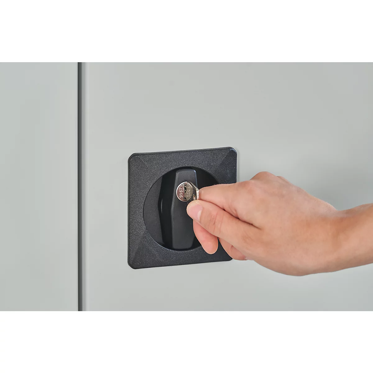 Een hand steekt een sleutel in een zwart slot. De achtergrond is lichtgrijs.