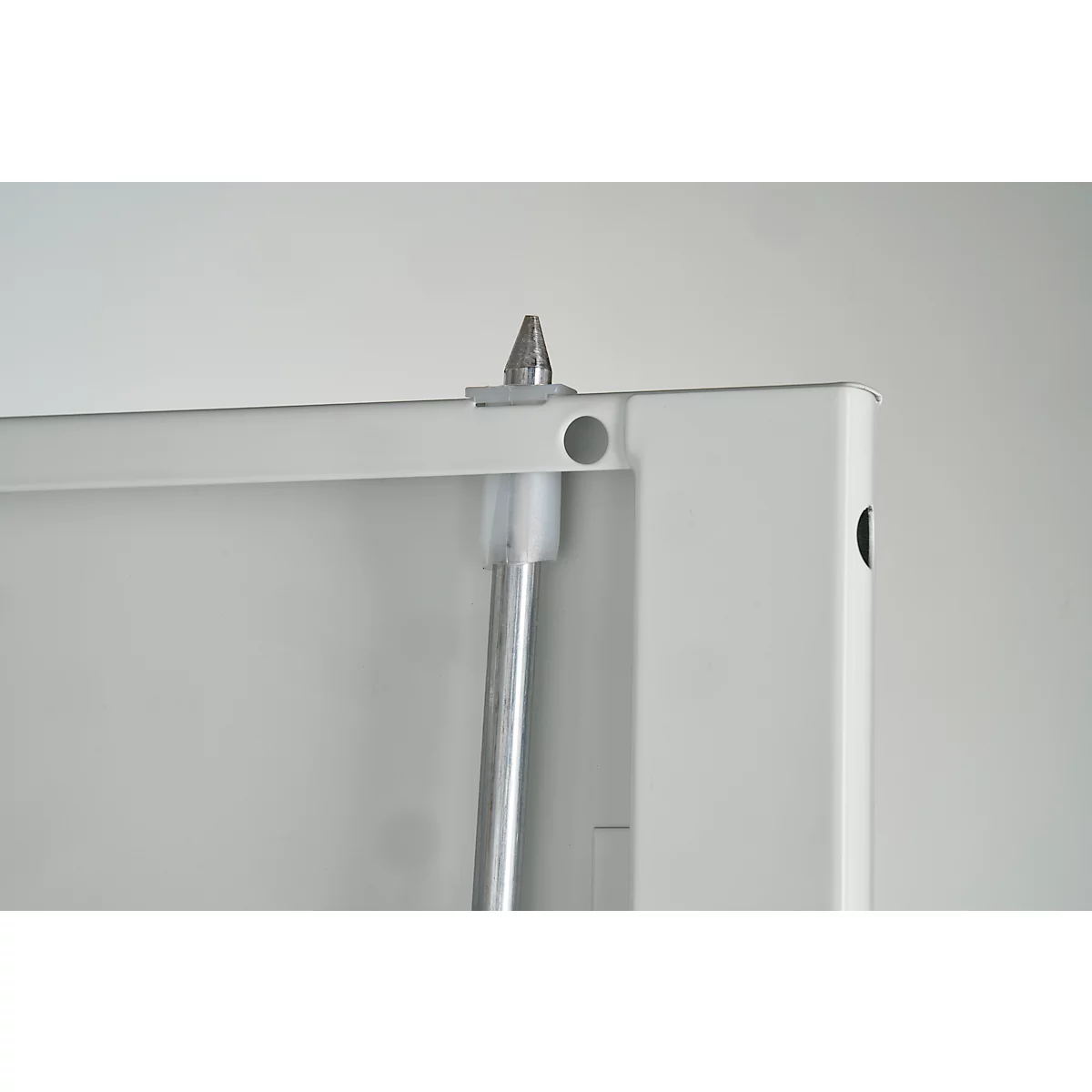 Close-up van een wit frame met een zilverkleurig metalen onderdeel en een conische punt.