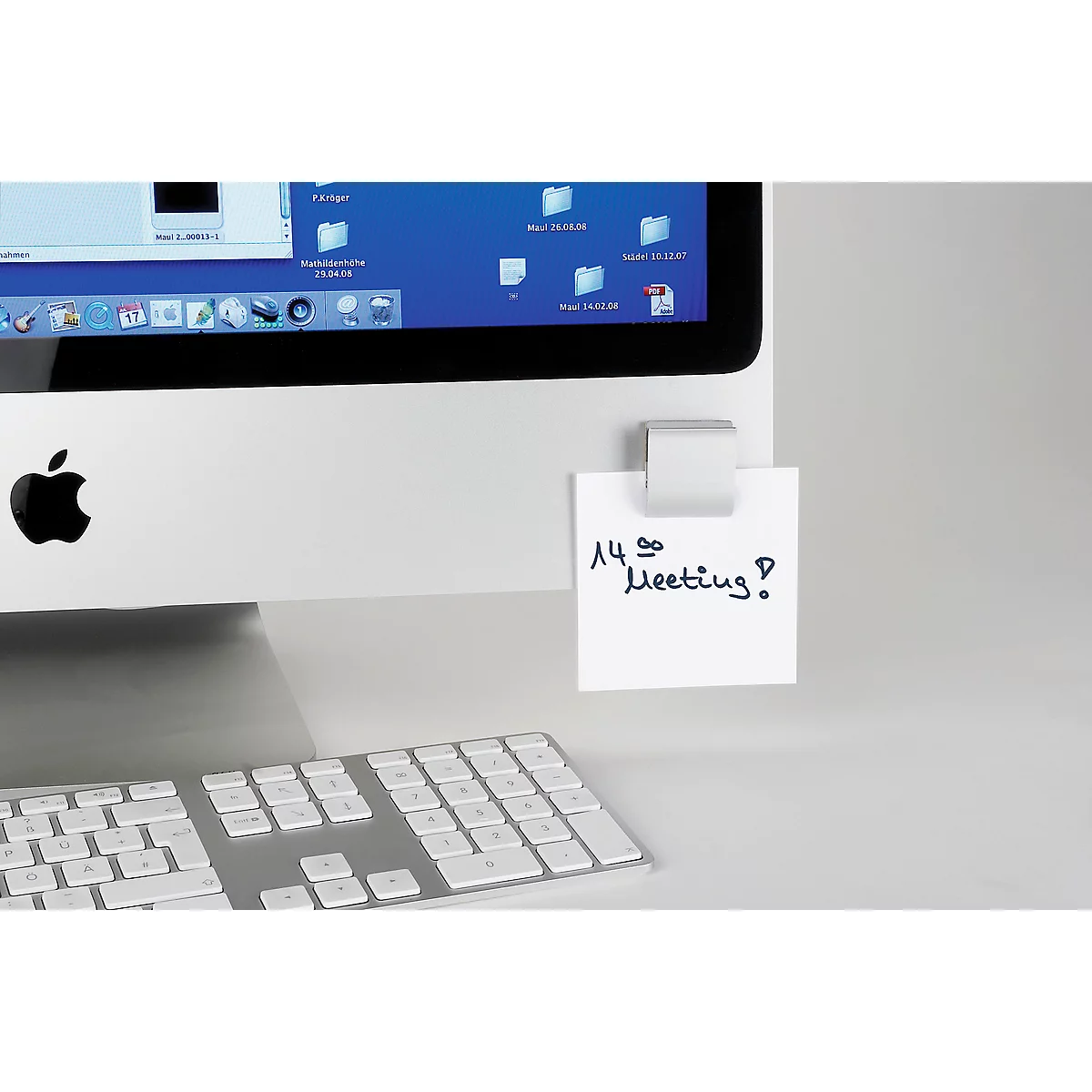 An iMac computer with a sticky note that says: "14:00 Meeting?".