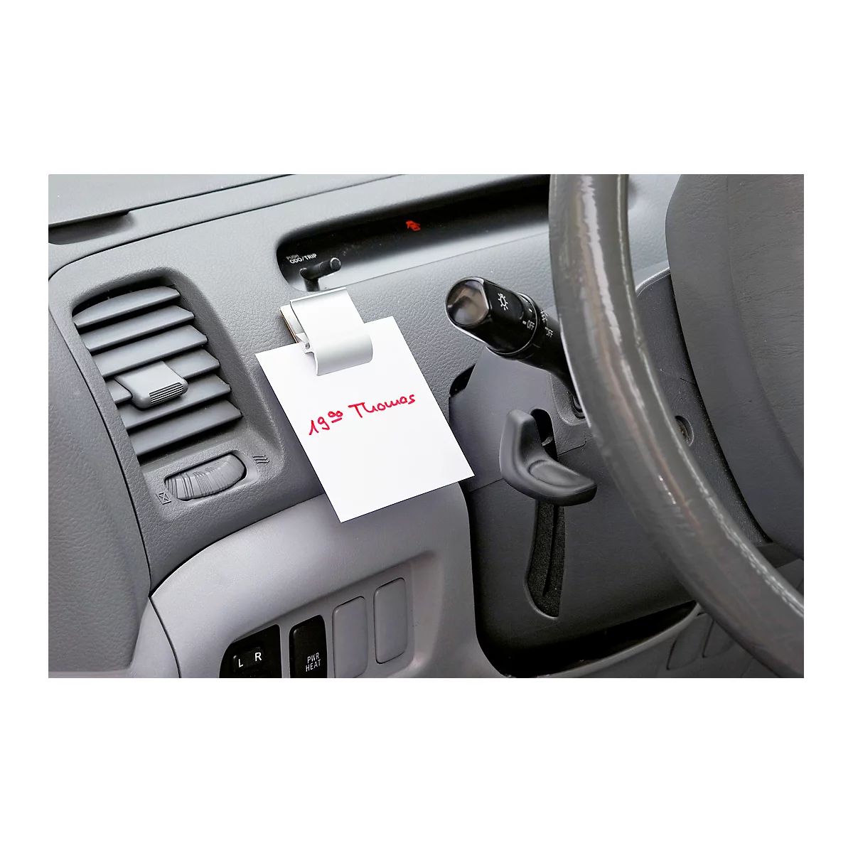 Note with red text, clip in car. Steering wheel, dashboard.