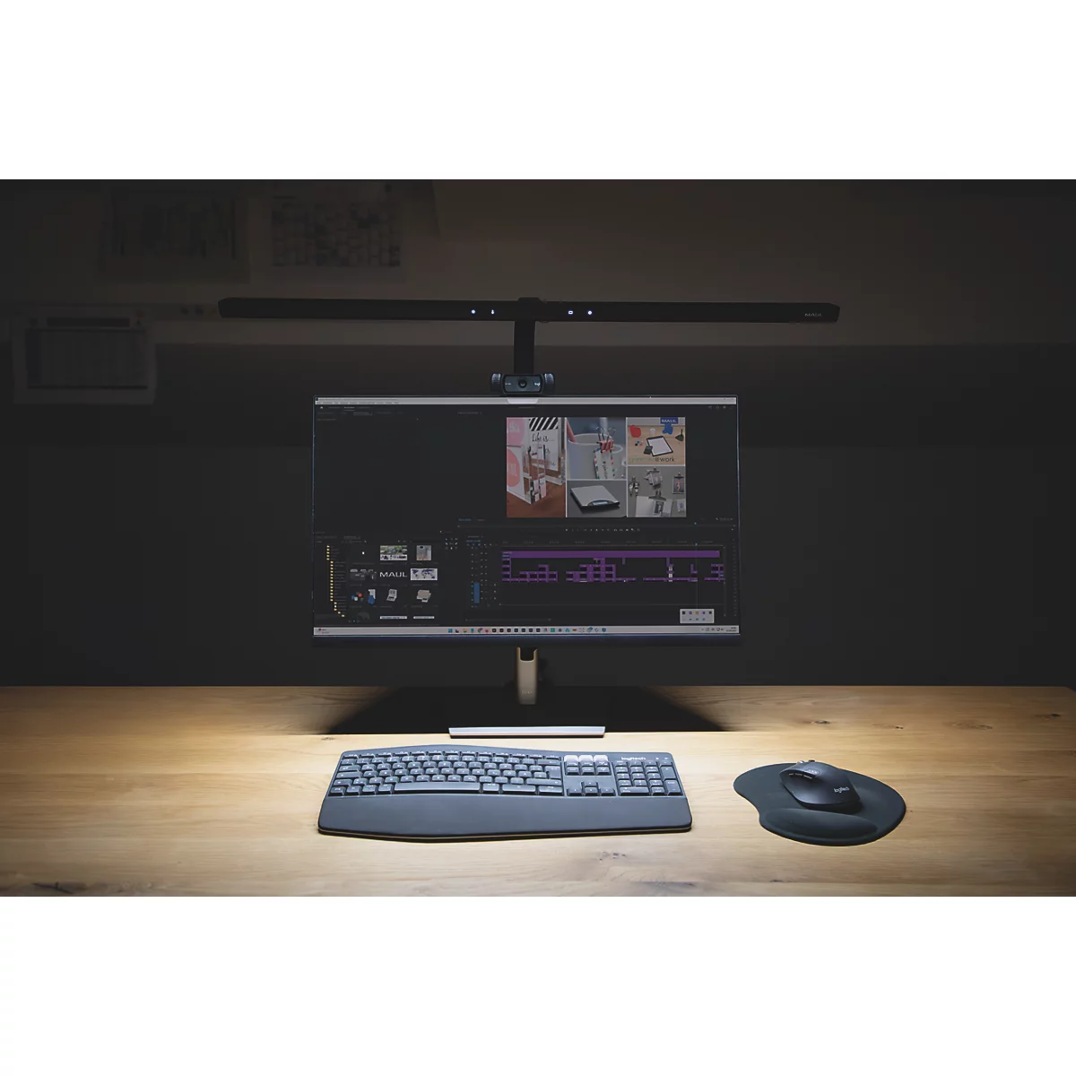 Bureau avec moniteur, clavier, souris et lampe. Dans le fond, une étagère avec des dossiers.