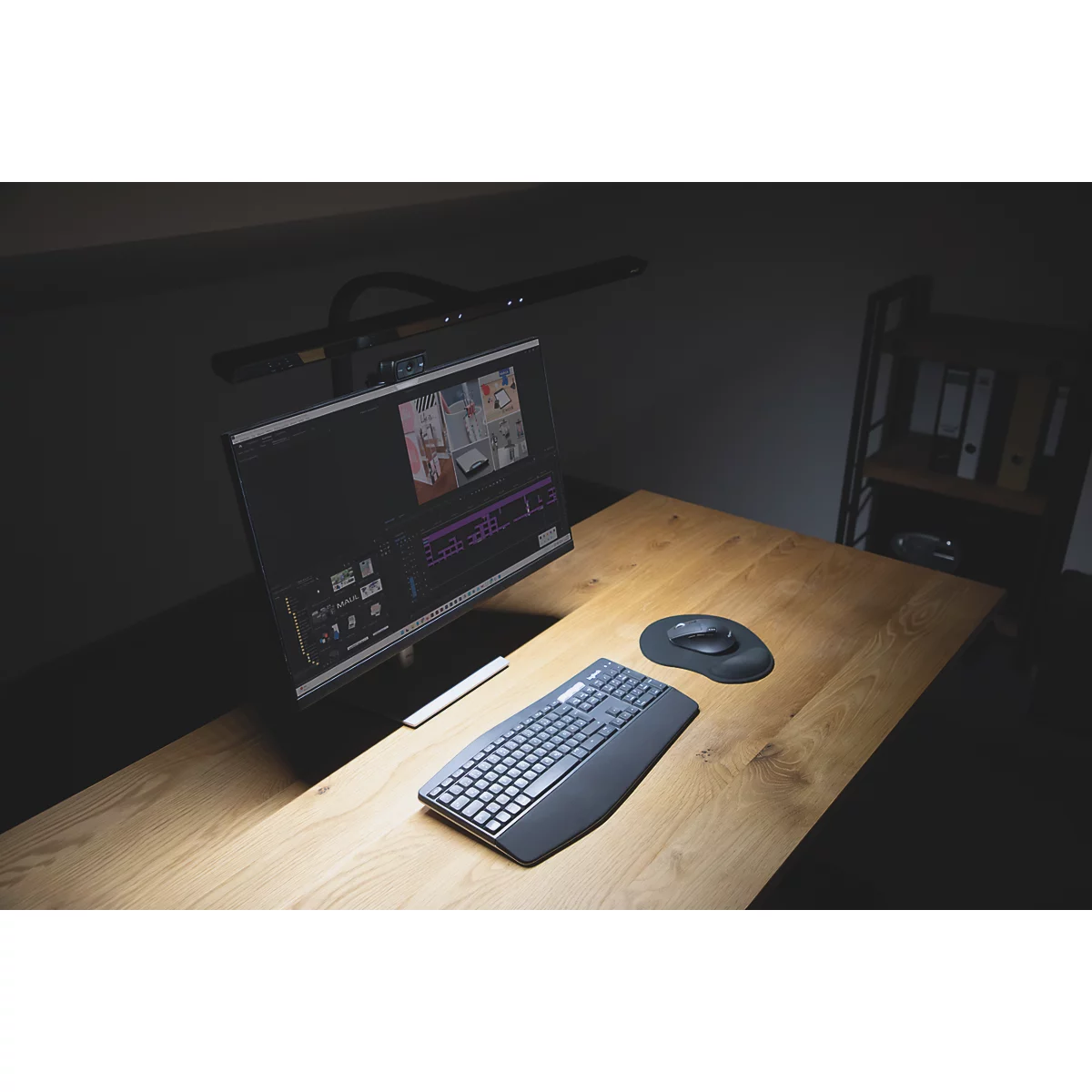 Zwei Monitore auf einem Schreibtisch. Auf den Monitoren sind Arbeitsabläufe zu sehen, darunter eine Videobearbeitungssoftware. Auf dem Schreibtisch sind Tastatur und Maus.