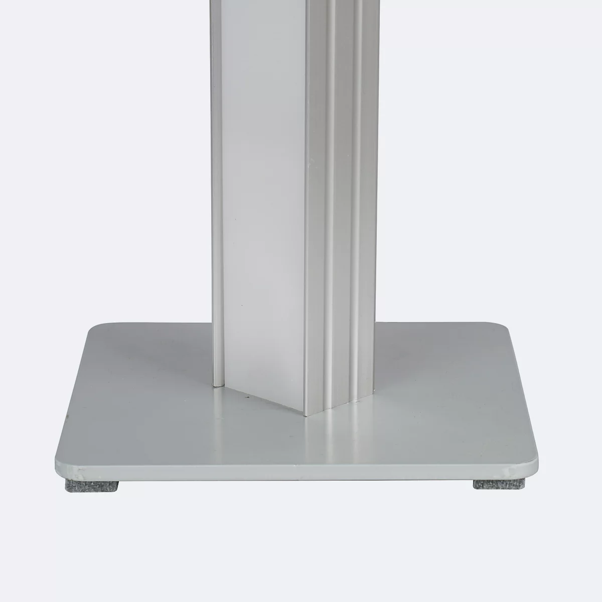 Detailaufnahme einer silbernen Säule mit quadratischem Fuß. Die Säule hat eine rechteckige Form und steht auf einer quadratischen Grundplatte.