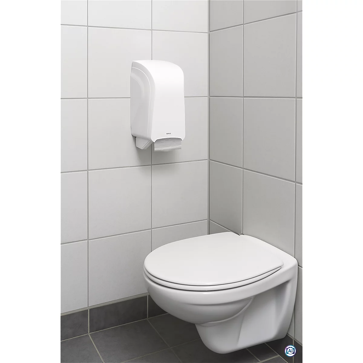 Witte papieren handdoekdispenser boven een wandtoilet. Tegelwand, grijze vloer.