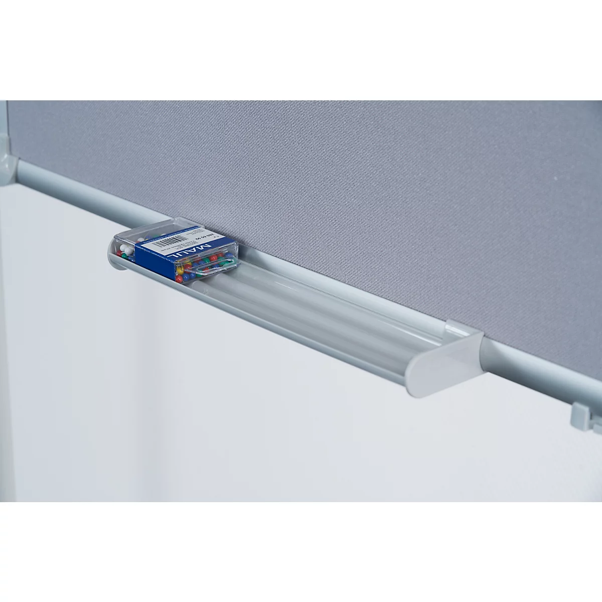 Close-up of a pinboard with a pen holder. There are drawing pins in a box.