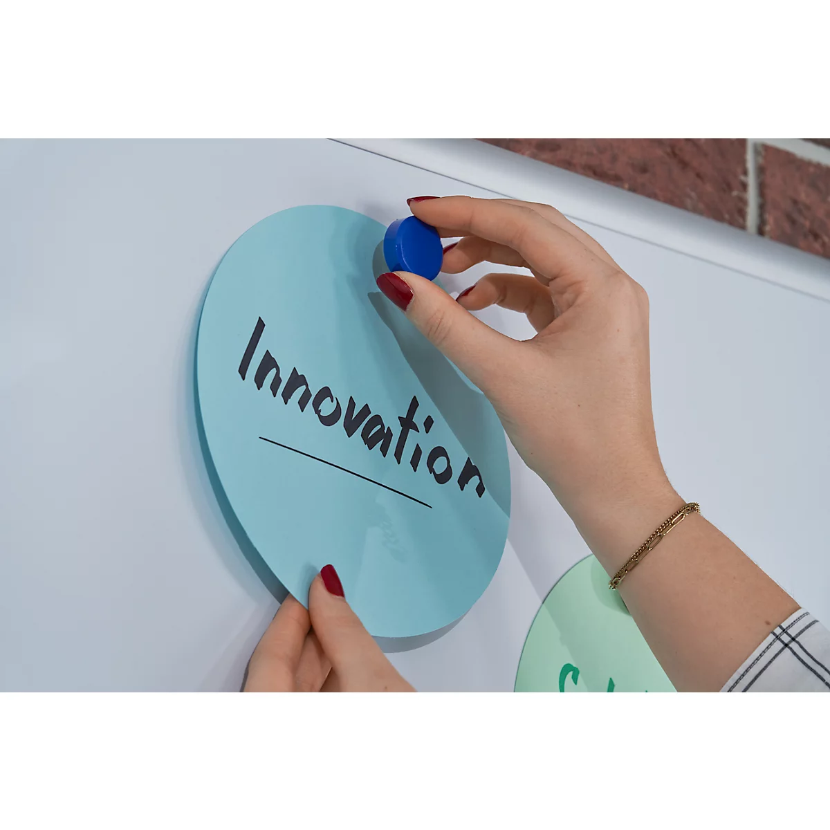 Handen plaatsen blauwe cirkels op een bord. Eén cirkel zegt "Innovatie."