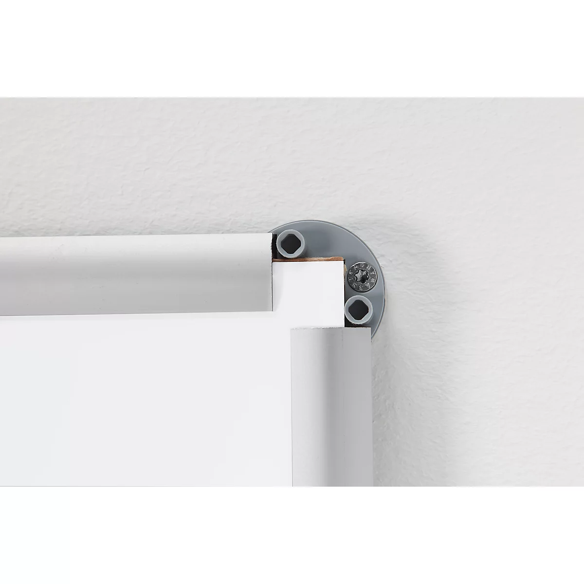 Corner of a frame, light gray. Corner joint with screws. Background: white wall.
