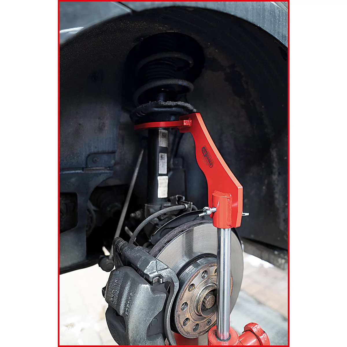 Nahaufnahme des Autos. Eine rote Federbein-Werkzeug an einem Stoßdämpfer und Bremsscheibe befestigt.