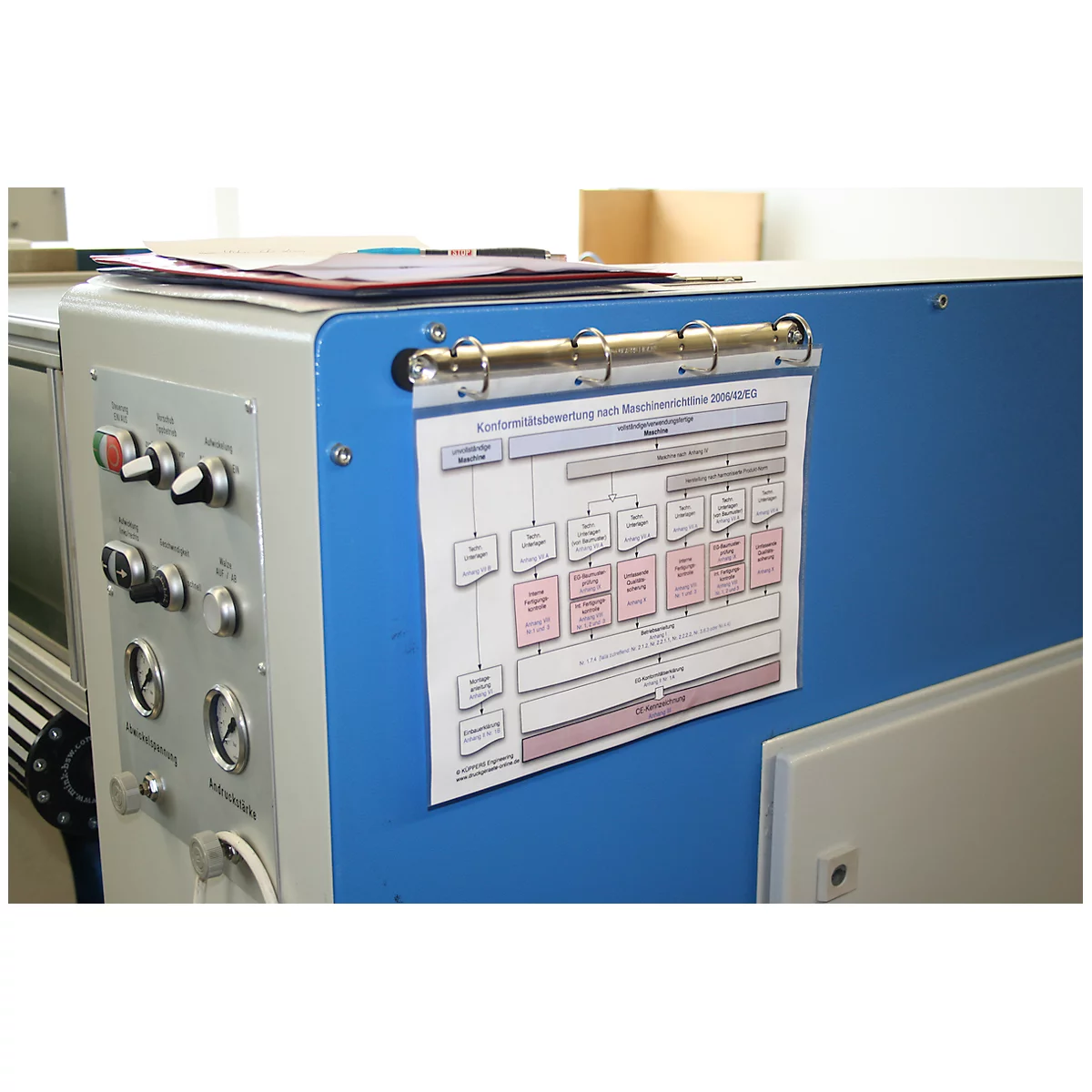 Machine avec panneau de contrôle et diagramme fixé sur un boîtier bleu.