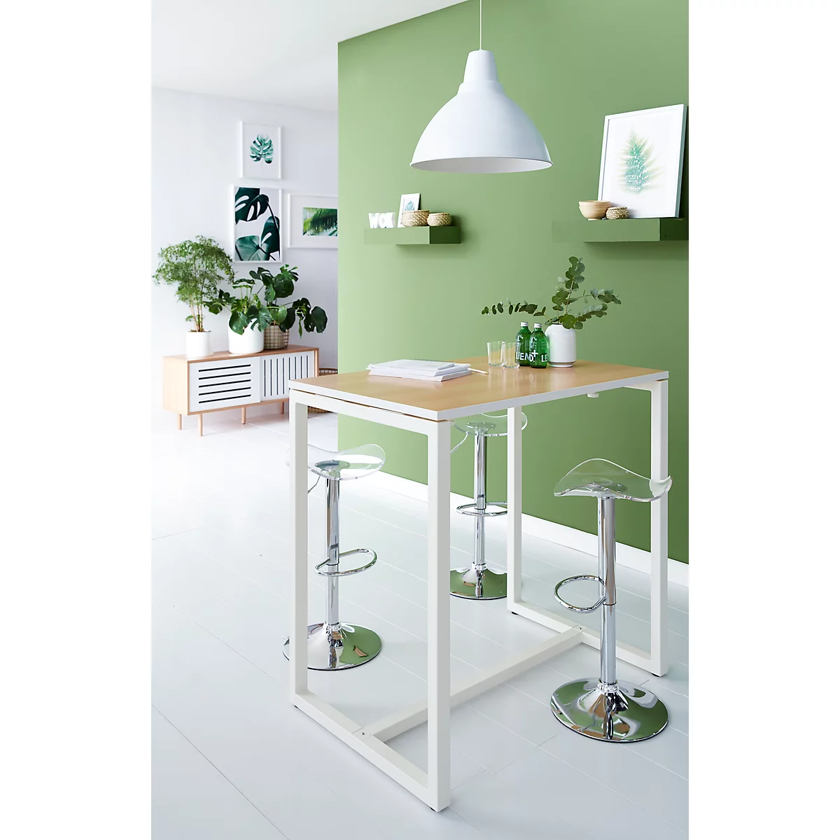 Modern kitchen with counter, bar stools, and plants. The background is green and the furnishings minimalist.