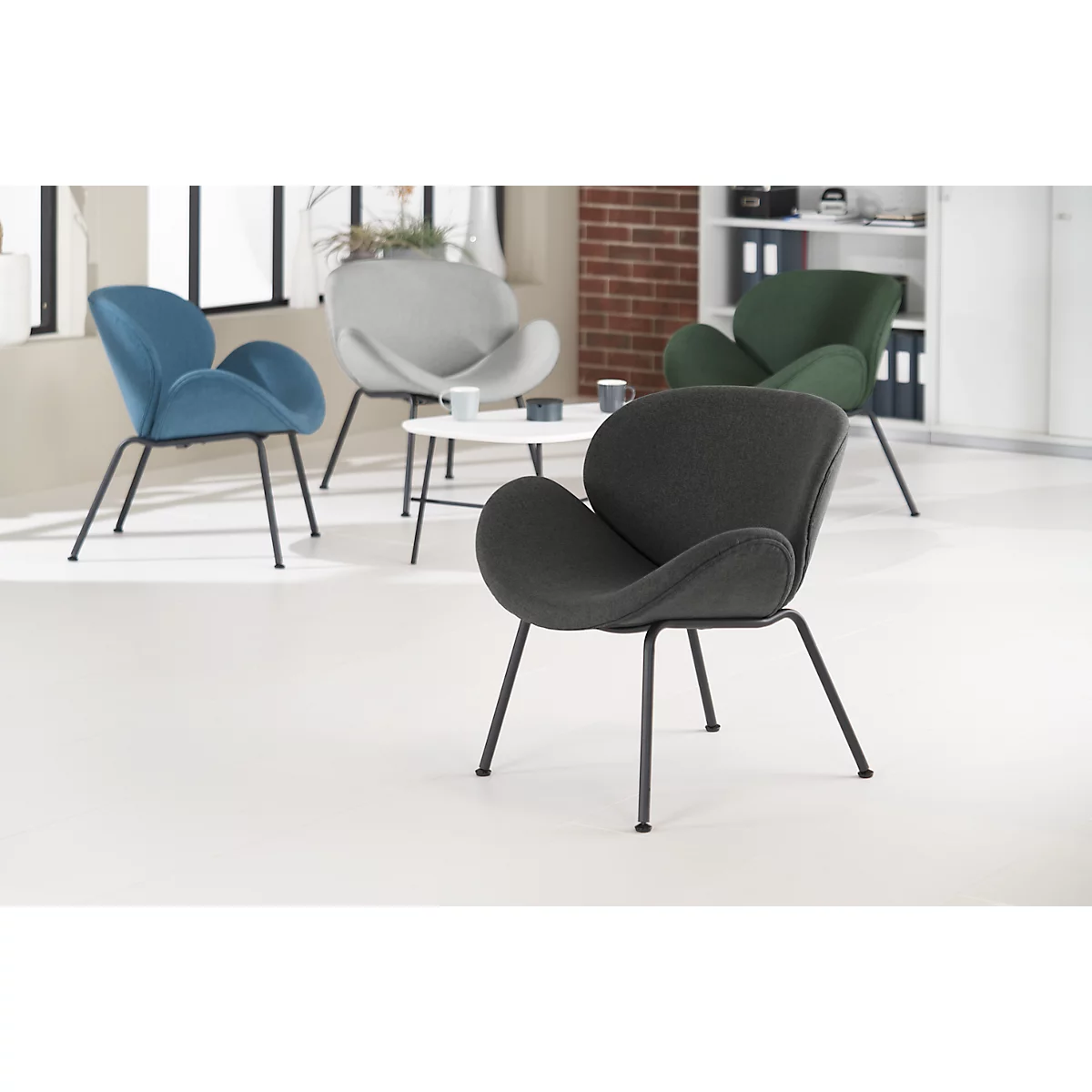 Verschiedene farbige Designer-Sessel mit Metallbeinen in einem Raum.