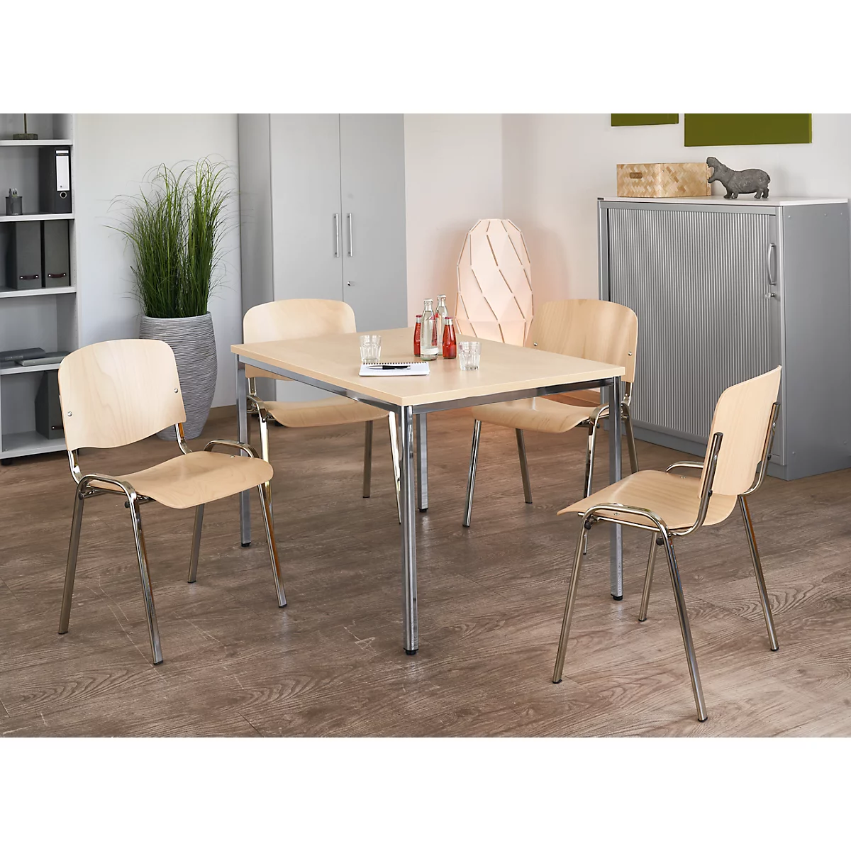 Meeting room with table and four chairs. Drinks and papers on the table.