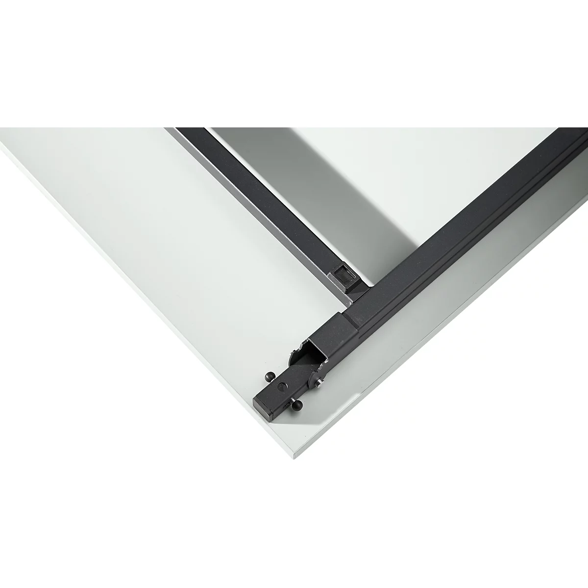 Detalle: Conexión de esquina de un marco de mesa metálico sobre fondo blanco. Metal negro, atornillado.