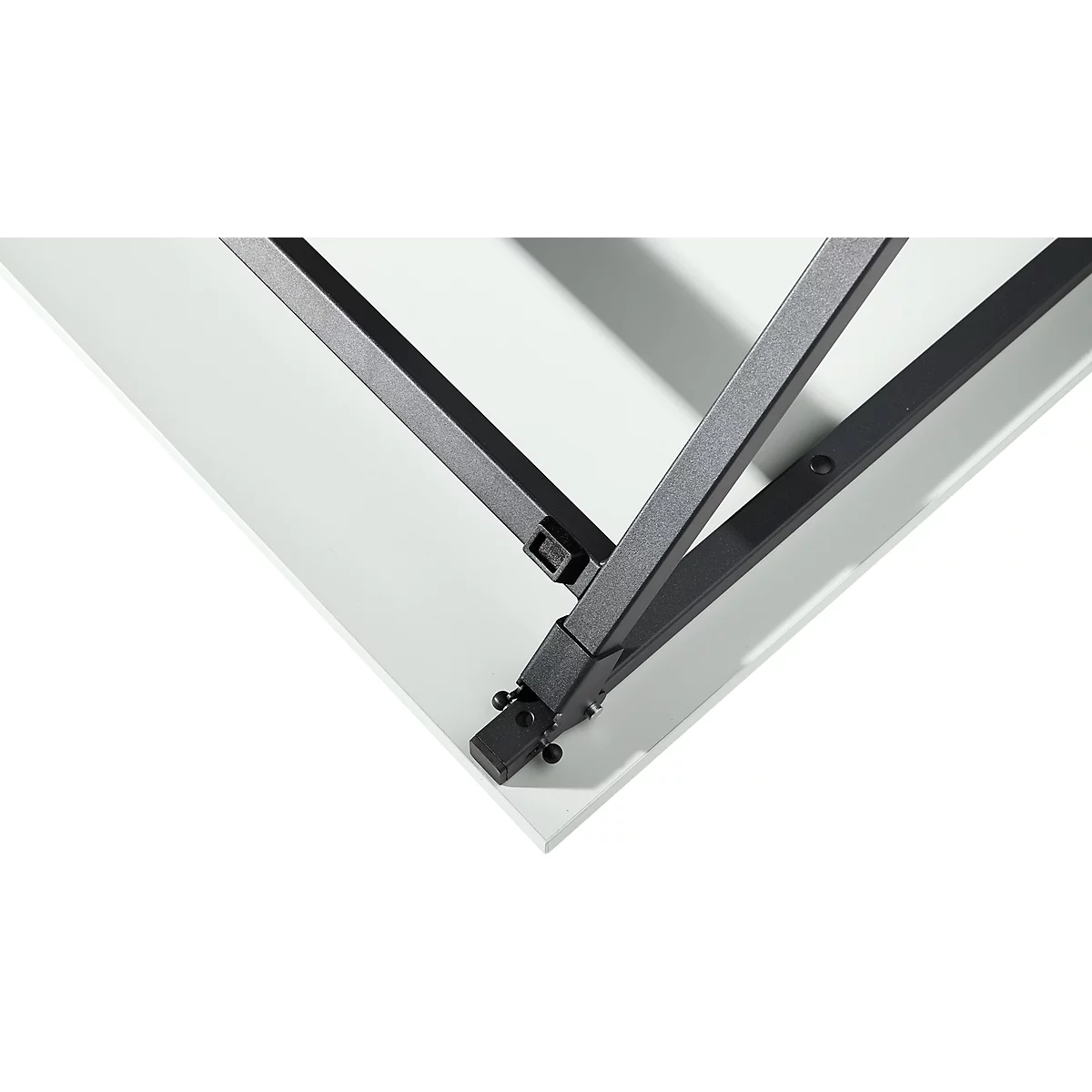 Primer plano: Unión de esquina de patas de mesa de metal. Las patas se encuentran en el punto de esquina sobre una superficie blanca.