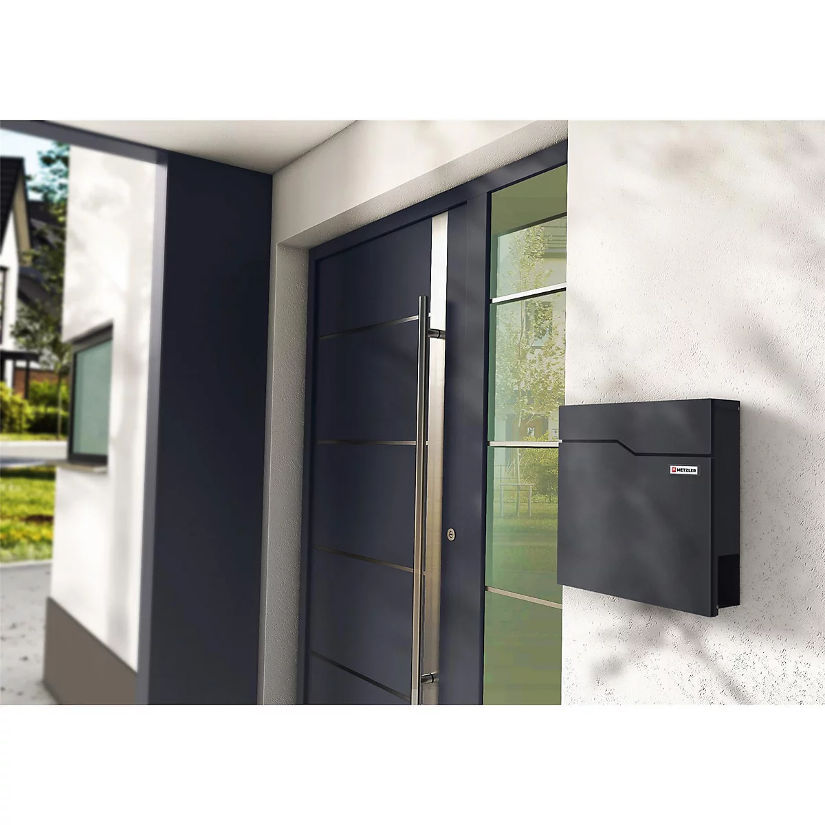 Schwarzer Briefkasten an einer Hauswand. Im Hintergrund eine Haustür.