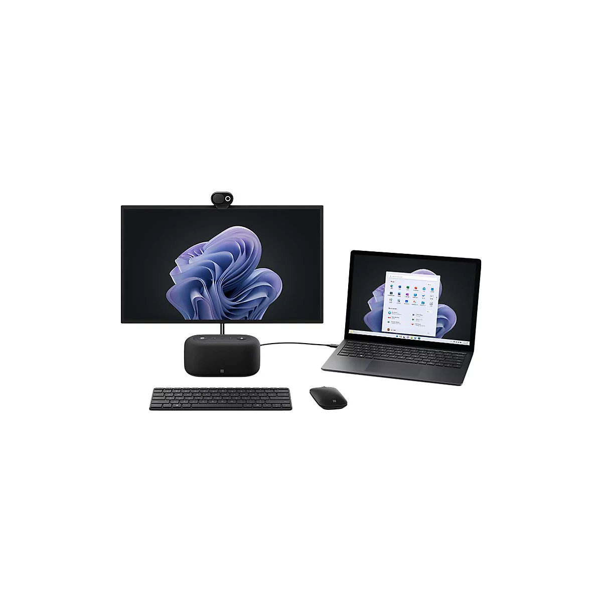 Kompletter Arbeitsplatz mit Laptop, Monitor, Tastatur und Maus. Der Monitor zeigt ein lila Windows-Hintergrundbild.