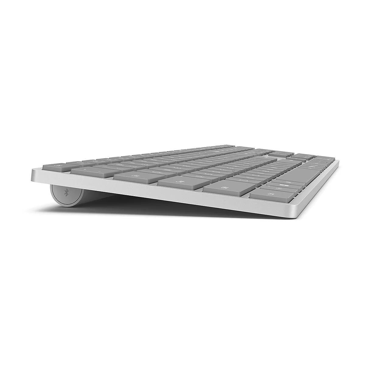 Flache, graue kabellose Tastatur in Seitenansicht vor weißem Hintergrund.