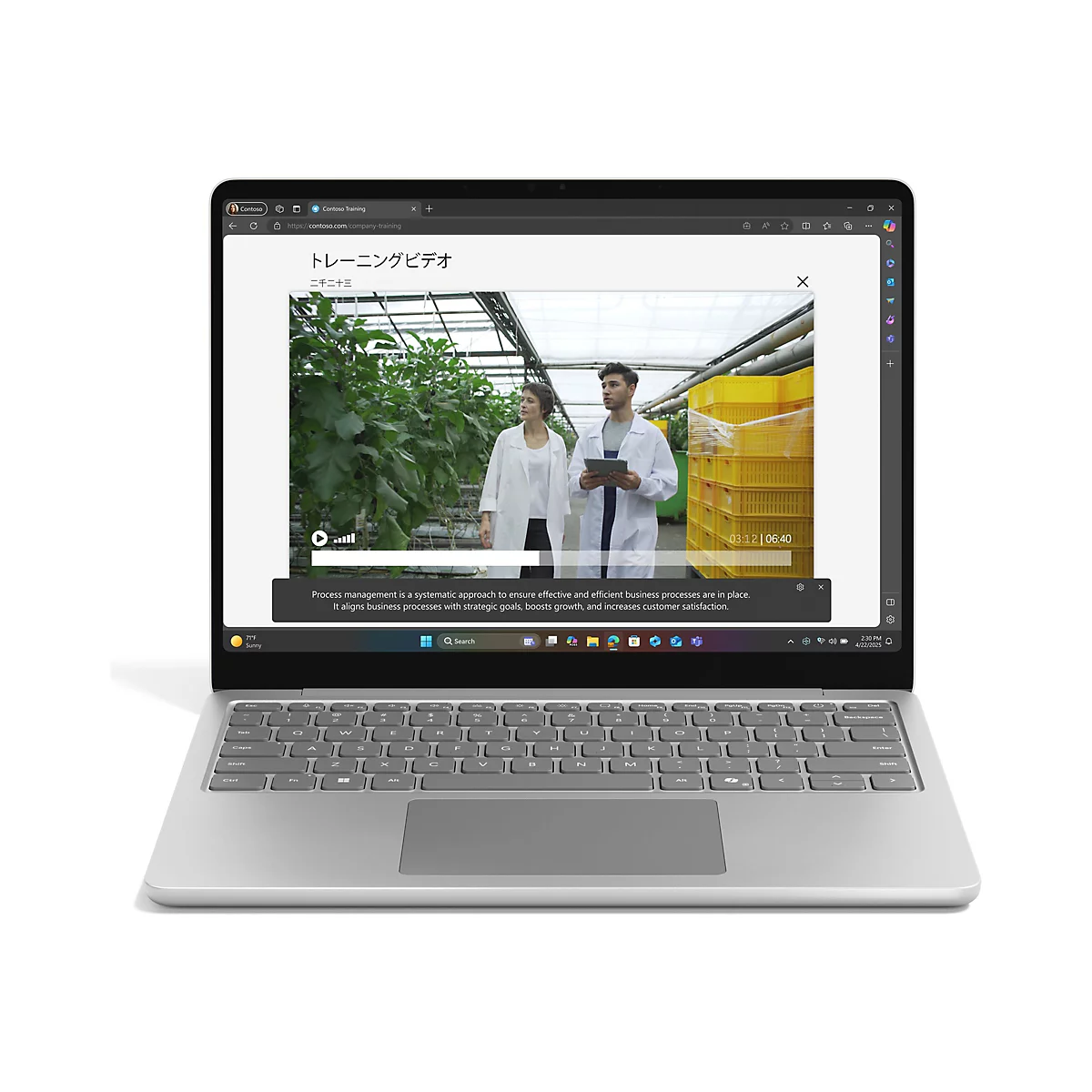 Ein Laptop zeigt ein Contoso-Schulungsvideo. Zwei Personen in weißen Laborkitteln stehen in einem Gewächshaus, während auf dem Bildschirm der Text "Prozessmanagement" erscheint.