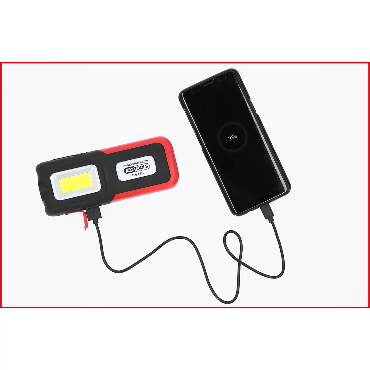 Ein rotes-schwarzes LED-Arbeitslicht lädt ein Mobiltelefon. Das Telefon zeigt 23% Ladung an.