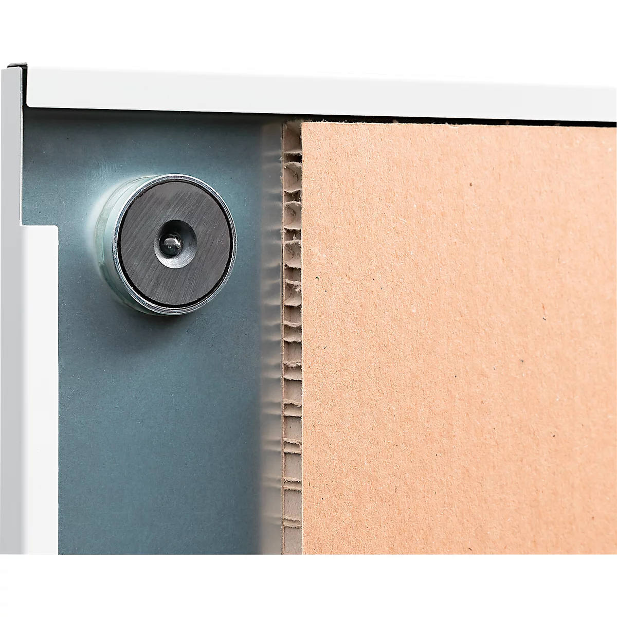 Gros plan d'une fermeture métallique. Carton à côté à droite. La fermeture est argentée et ronde.