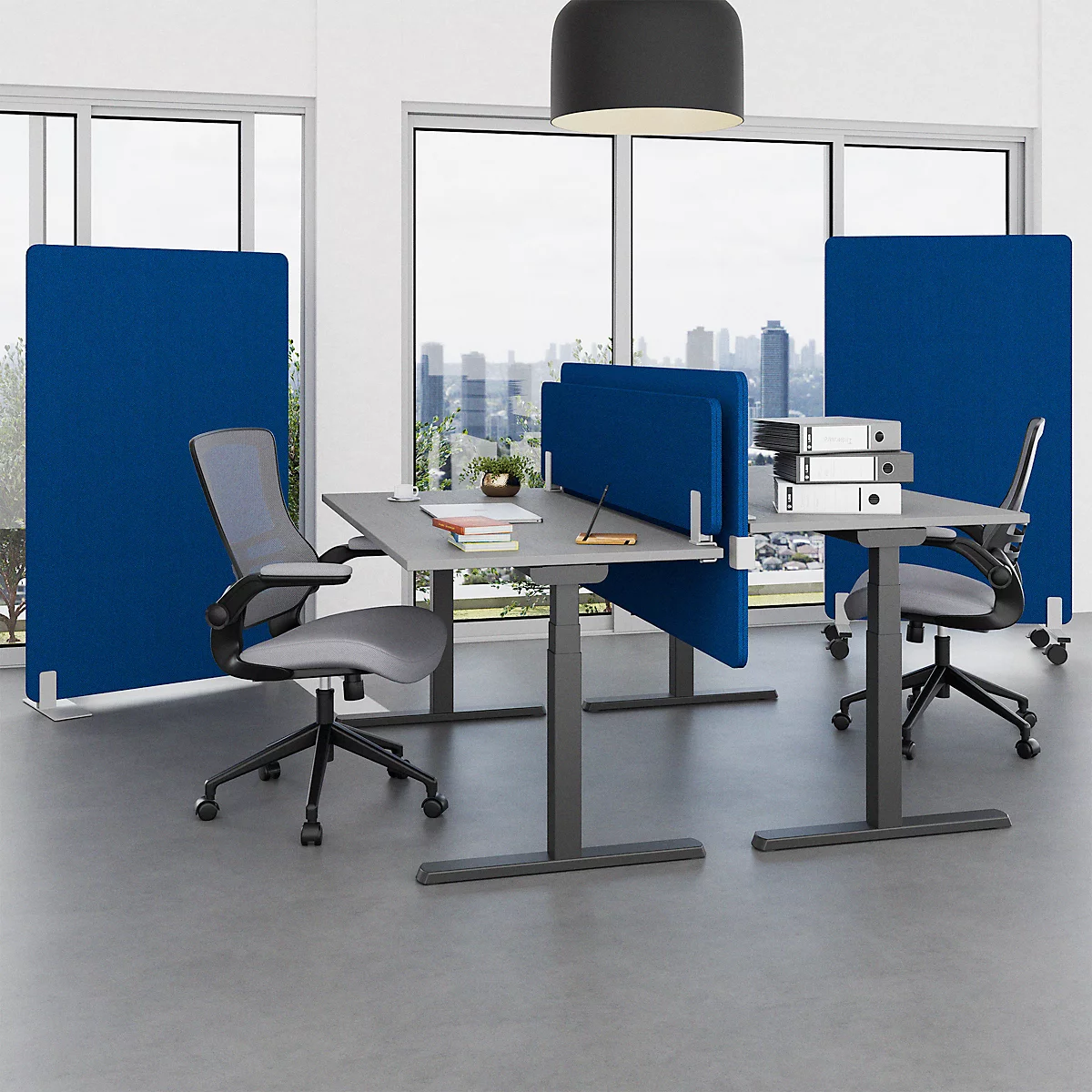 Office featuring desks, chairs and blue partitions. Windows in the background with city view.