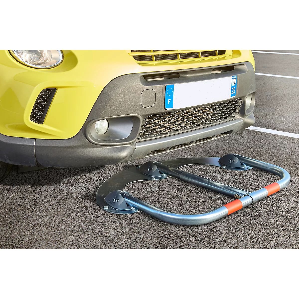 Yellow car with parking barrier in the foreground.