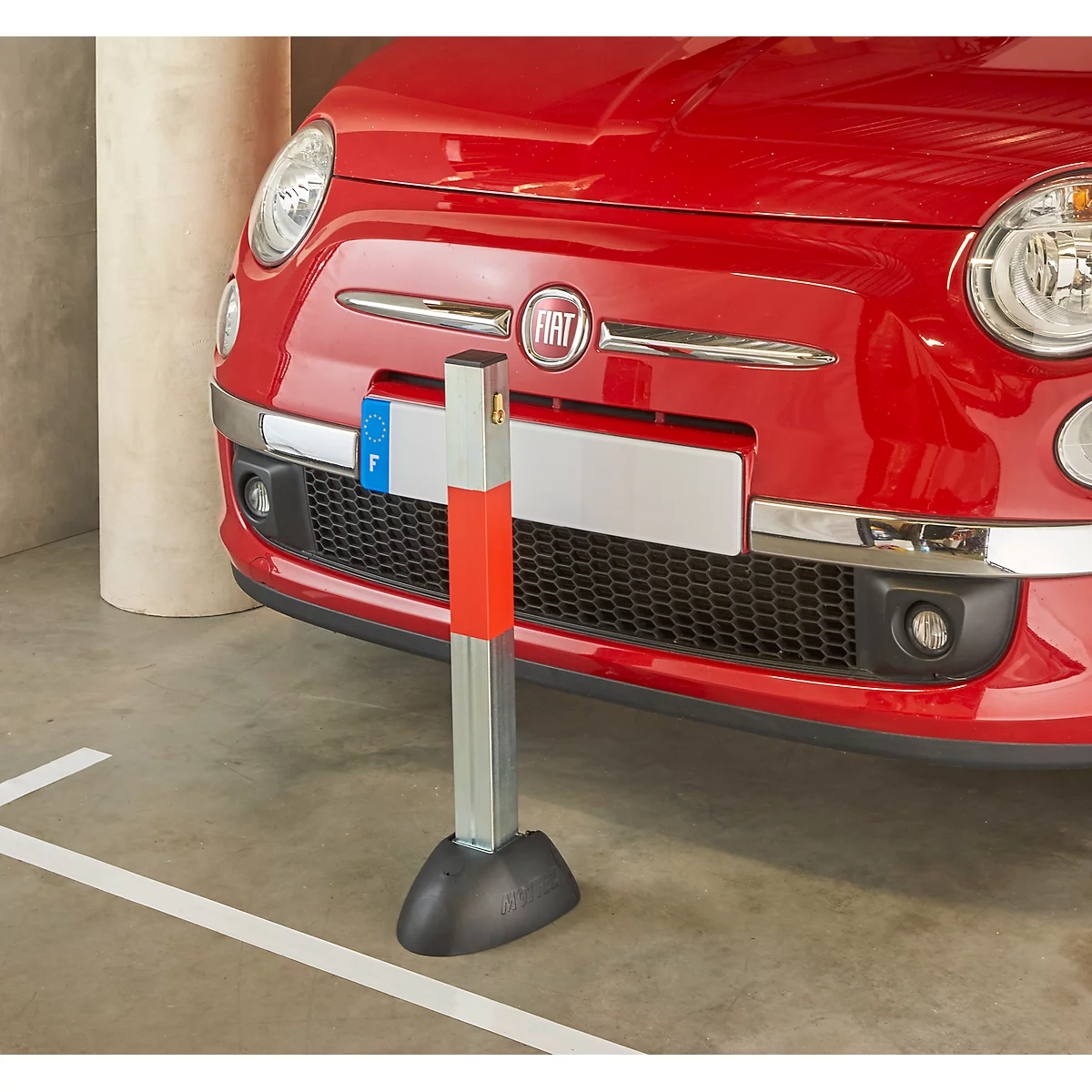 Red Fiat 500 in front of a bollard in a garage. The front of the car and the bumper are visible. The bollard is silver, orange and black.
