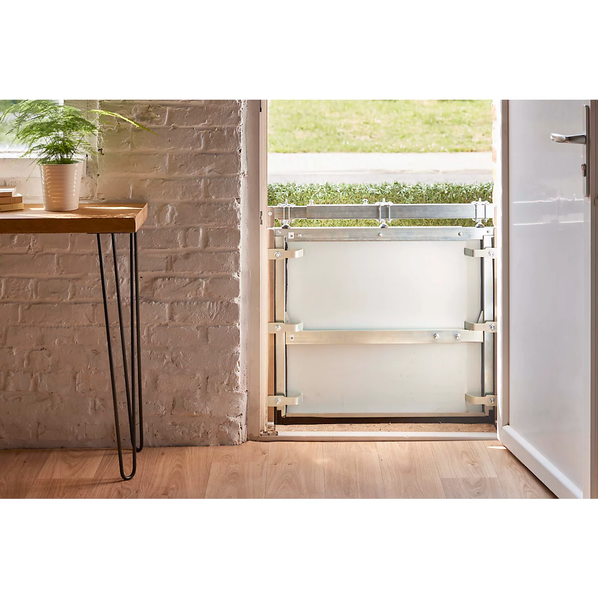 Een deur met waterkering in een kamer. Rechts is een open deur met een waterkeringssysteem.