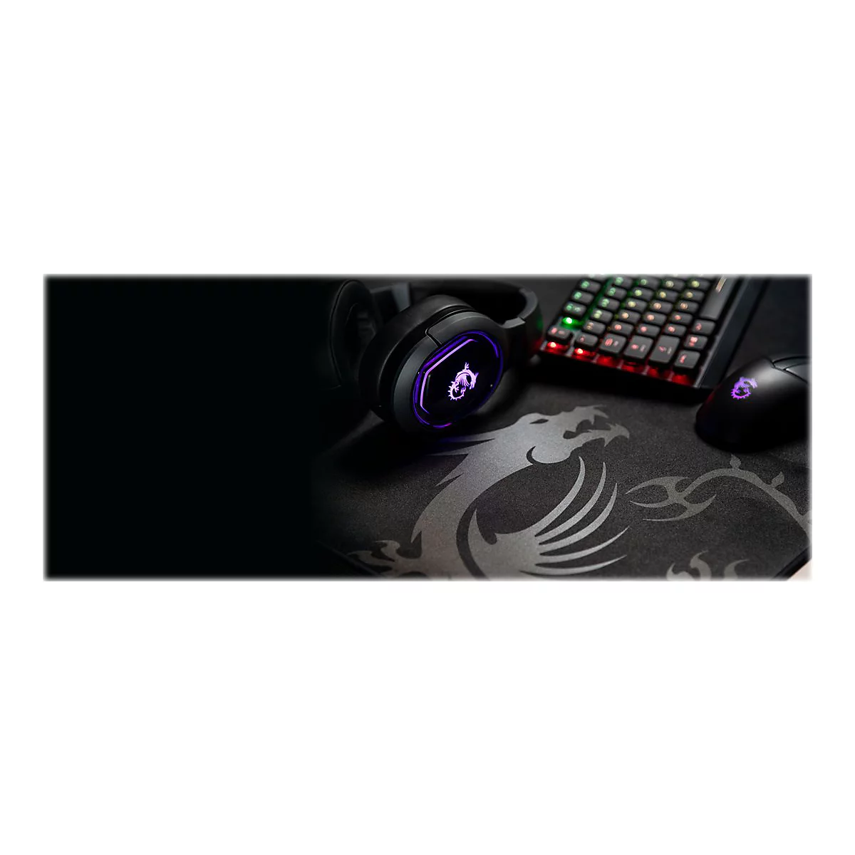 Schwarzes Gaming-Zubehör: Kopfhörer, Tastatur, Maus und Mauspad mit Drachenlogo. Tastatur beleuchtet. Dunkler Hintergrund.