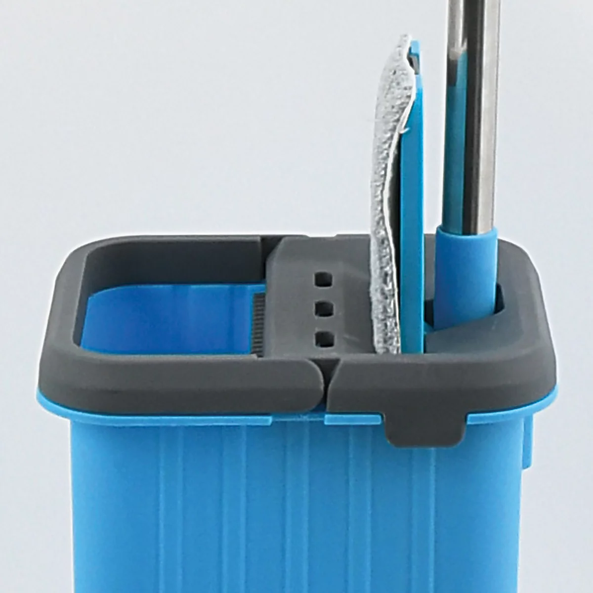 Nahaufnahme eines blauen Eimers mit grauem Deckel, Mopp und Stiel.