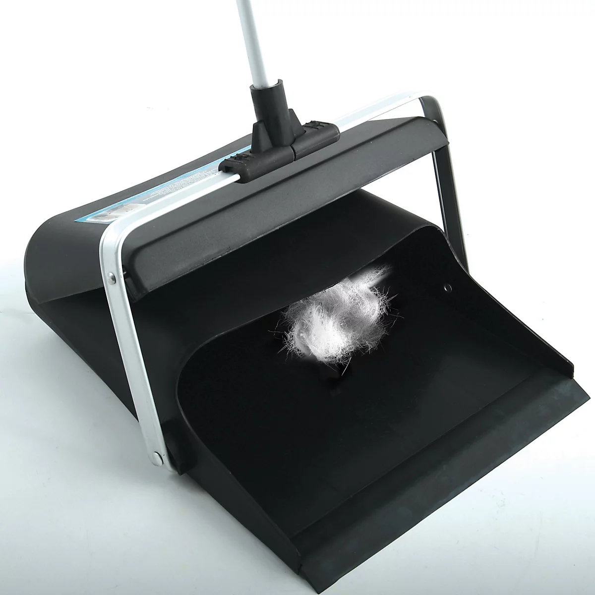 Schwarze Kehrschaufel mit Griff, darin ein weisser Wollballen.