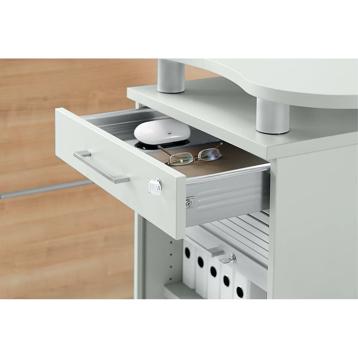 Open bureaula met muis en bril erin. Donker interieur met lichtgrijze voorkant en zilveren handvat. Archiefmappen beneden.