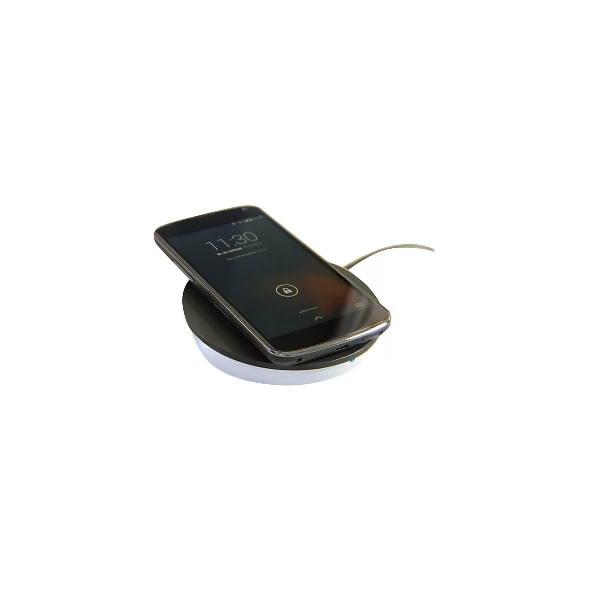 Ein schwarzes Smartphone liegt zum induktiven Laden auf einer runden, weiß-schwarzen Ladestation.