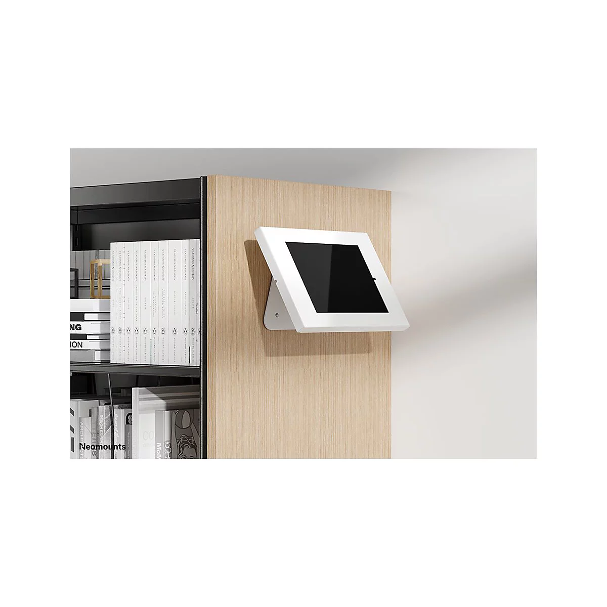 WeiÃŸes Tablet mit schwarzem Bildschirm an Holzverkleidung montiert. Daneben BÃ¼cherregal.