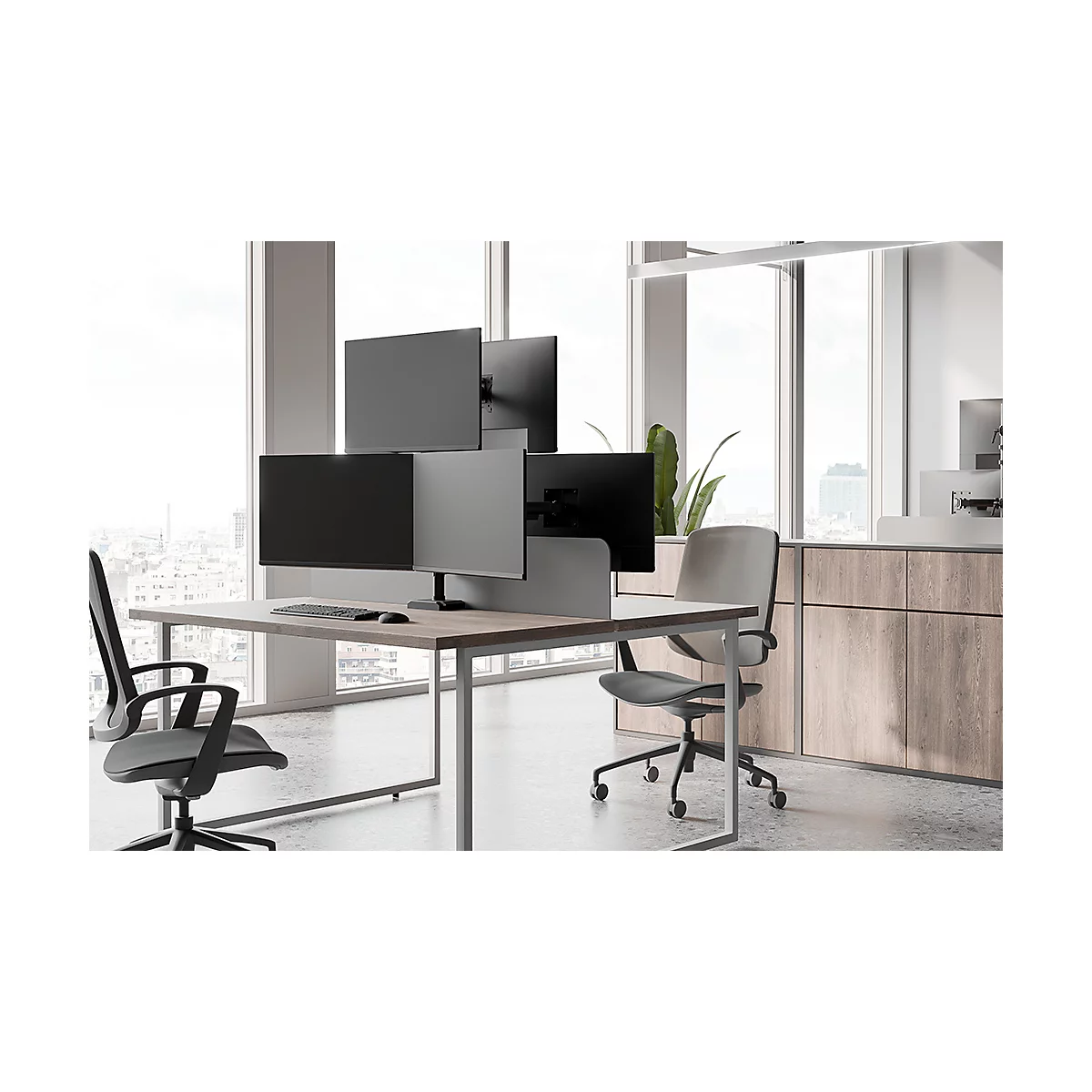Büro mit mehreren Monitoren an einem Schreibtisch, zwei Bürostühle.