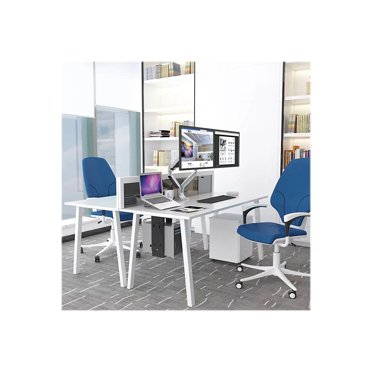 Büro mit weißem Schreibtisch, zwei blauen Stühlen und Computermonitoren. Ein Laptop und Bücherregale sind zu sehen.