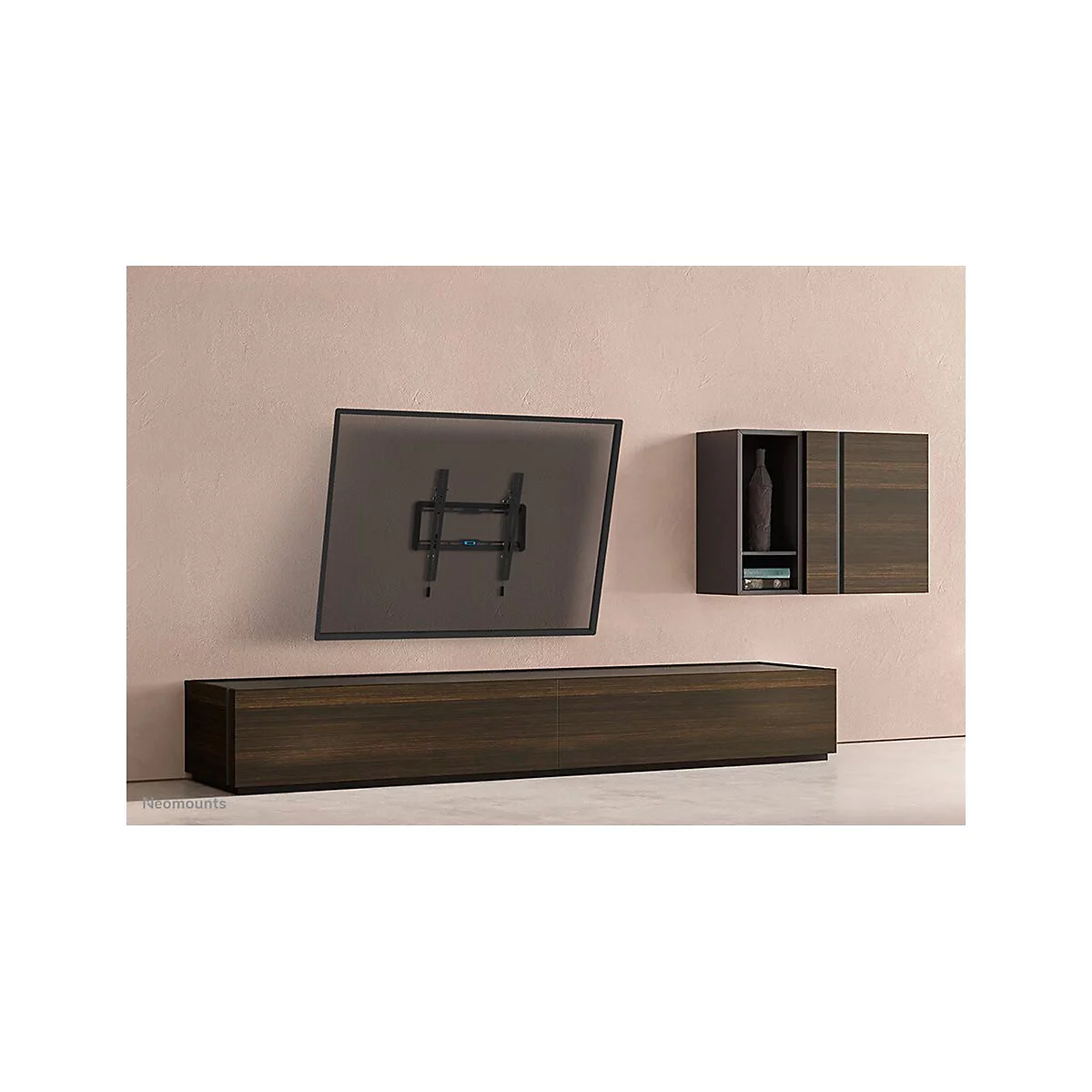TV-Halterung an Wand, darunter eine niedrige Kommode und ein Schrank mit Dekorationsgegenständen.