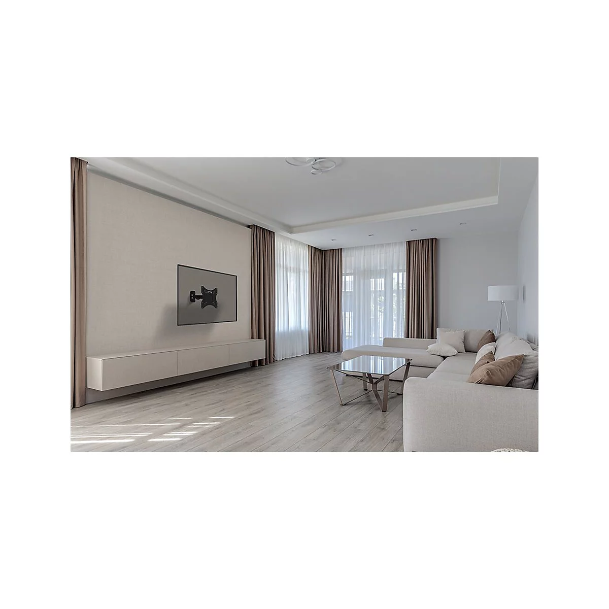 Wohnzimmer mit montiertem TV, helle Wandfarbe, beigefarbene Vorhänge, helles Sofa, Holzboden. 