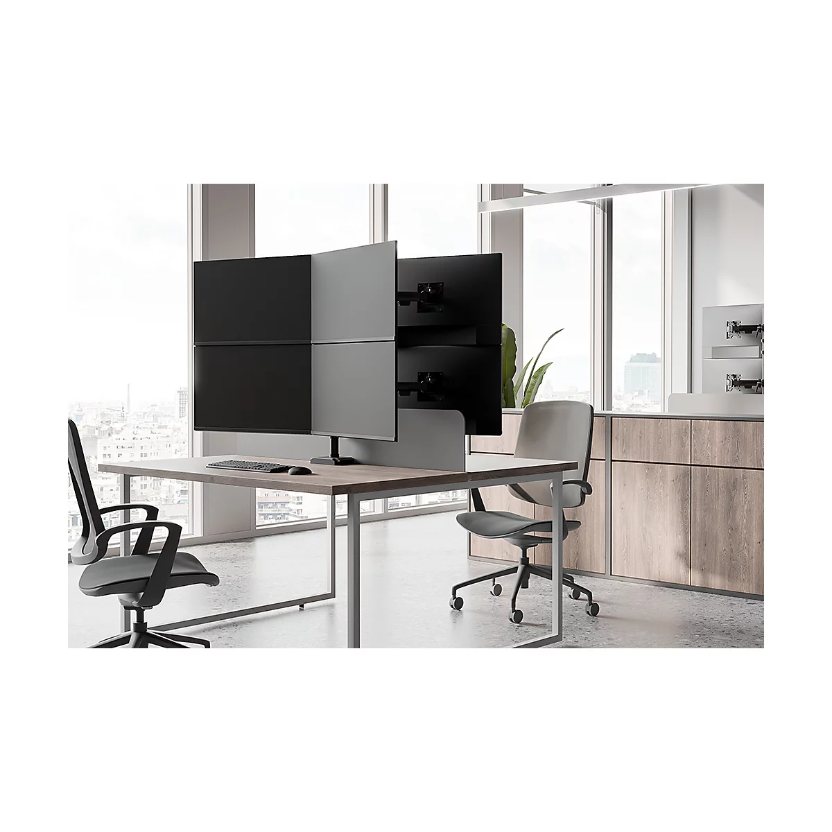 Bureau avec plusieurs écrans et chaises. L'espace est clair et moderne.