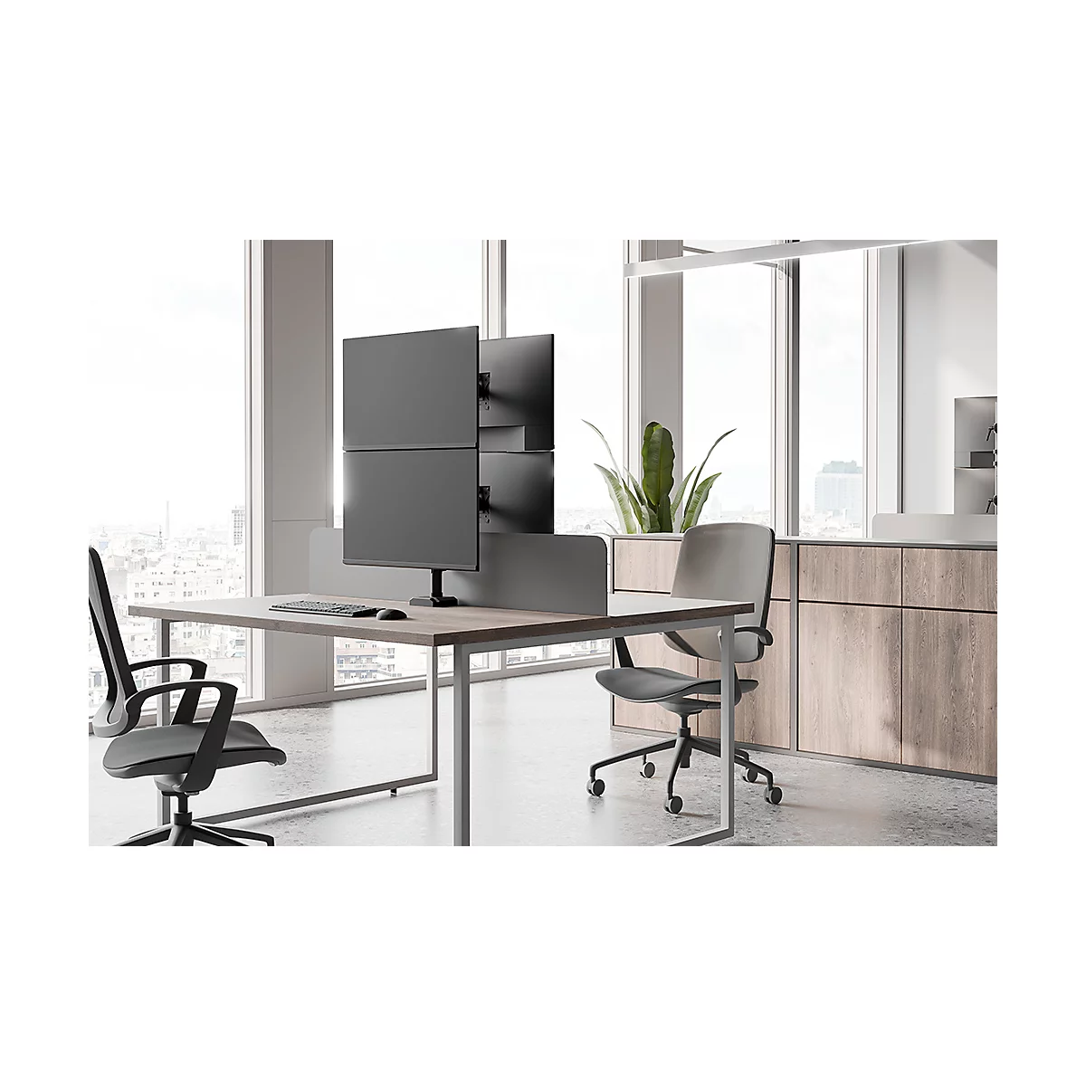 Bureau avec bureau, plusieurs moniteurs, chaises et plante.