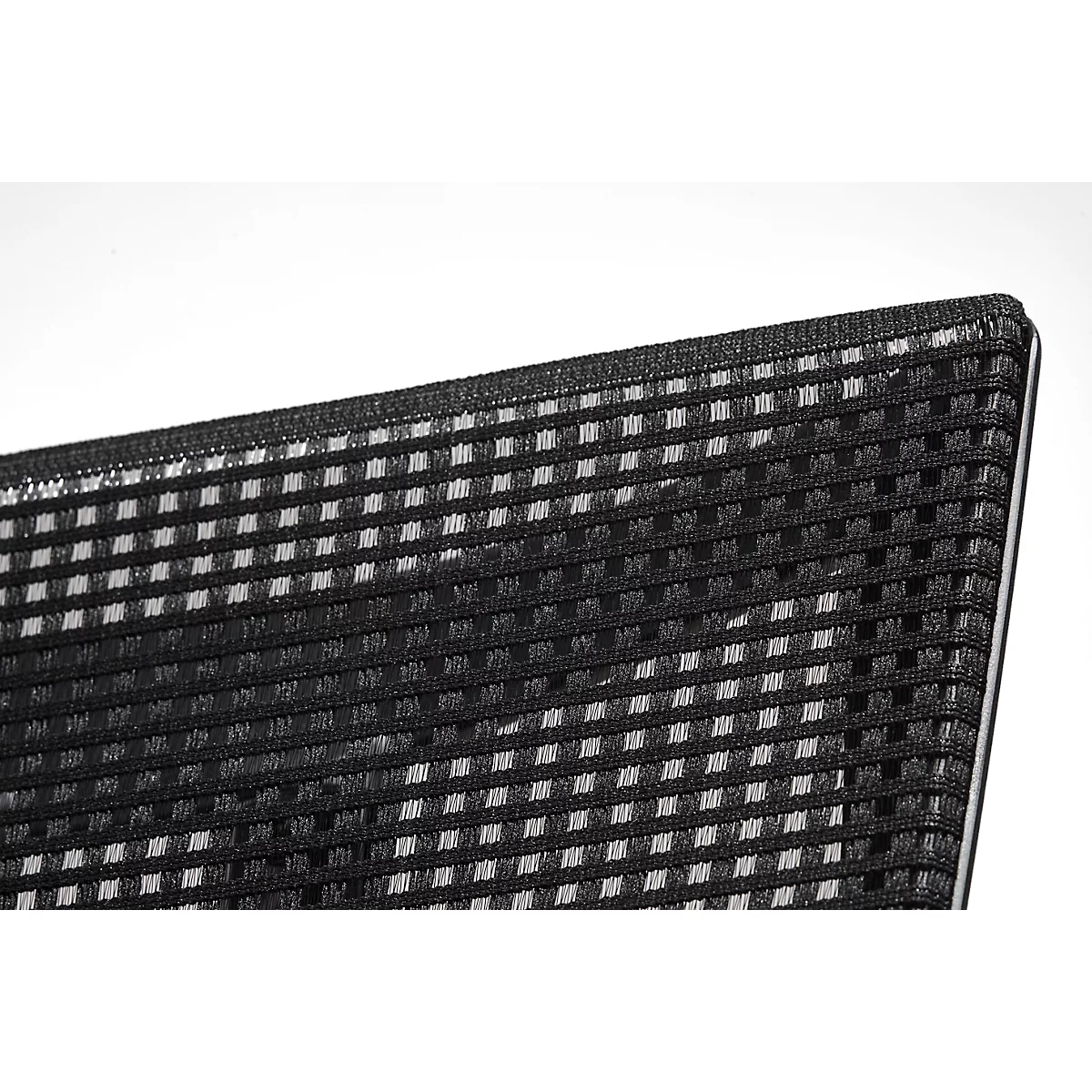 Close-up of a corner of black, square patterned fabric against a white background. The fabric is highly textured.