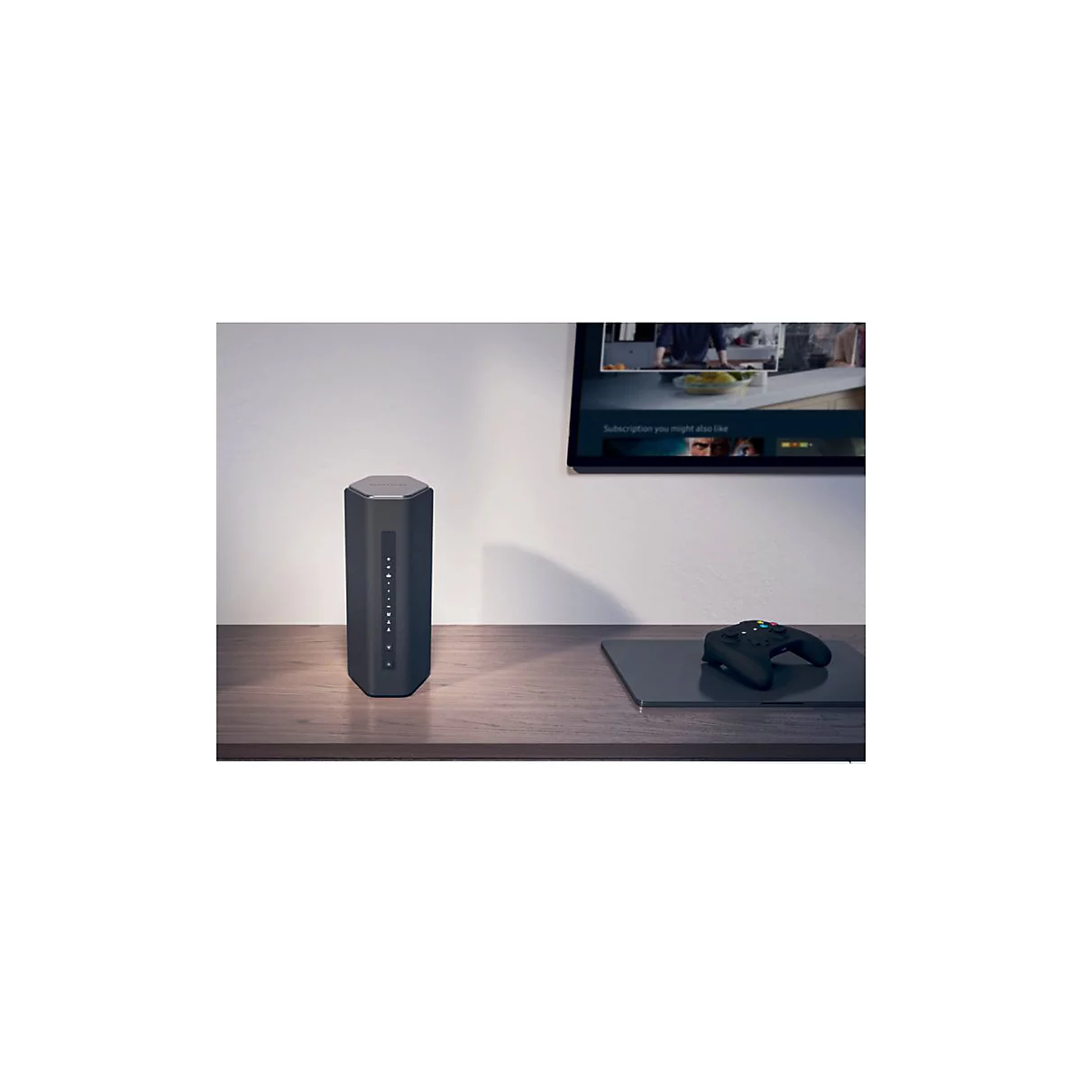 Dunkler, sechseckiger Router auf einem Holztisch. Ein Fernseher und ein Gamepad sind ebenfalls im Bild.