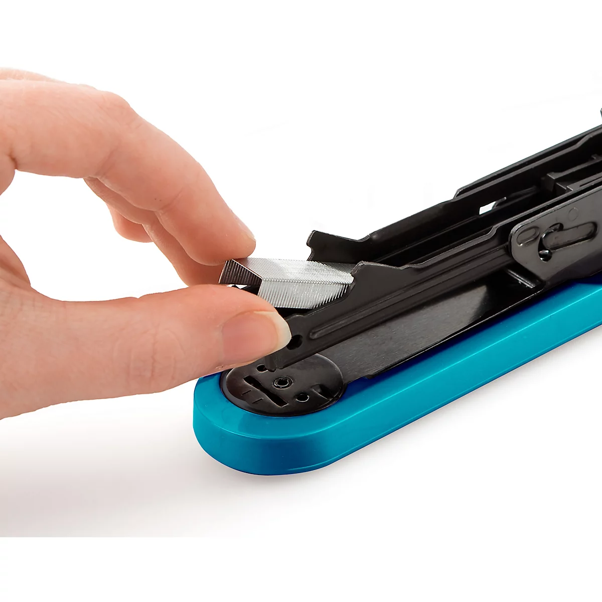 Close-up of a hand inserting a staple into a black stapler with a turquoise base.