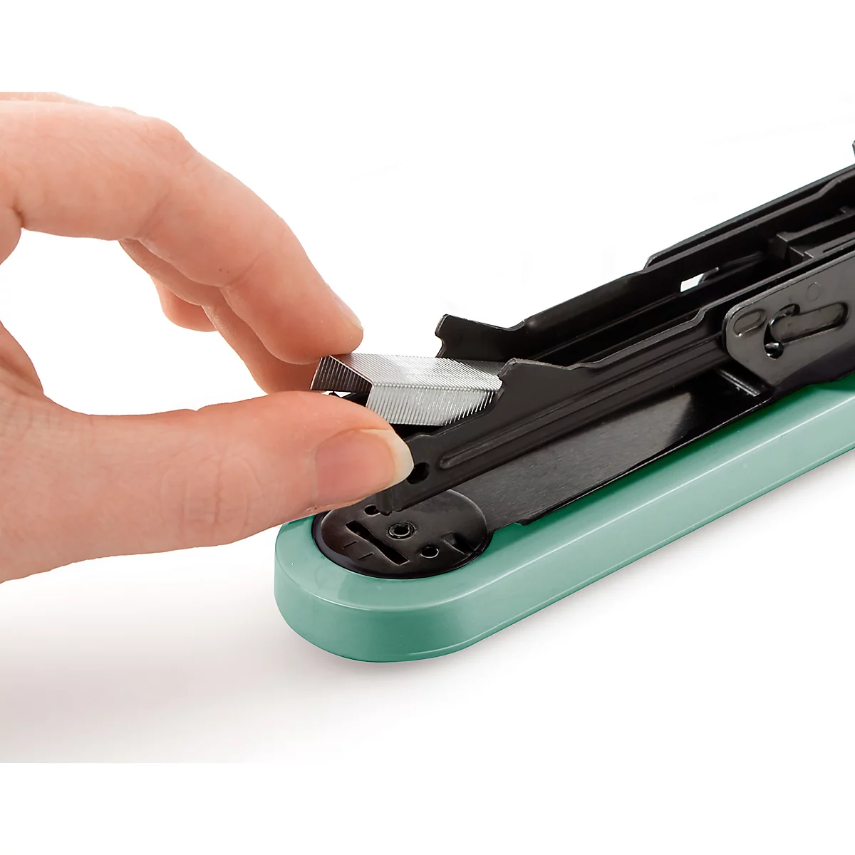 Close-up of a hand inserting a silver stapler head into a green stapler.
