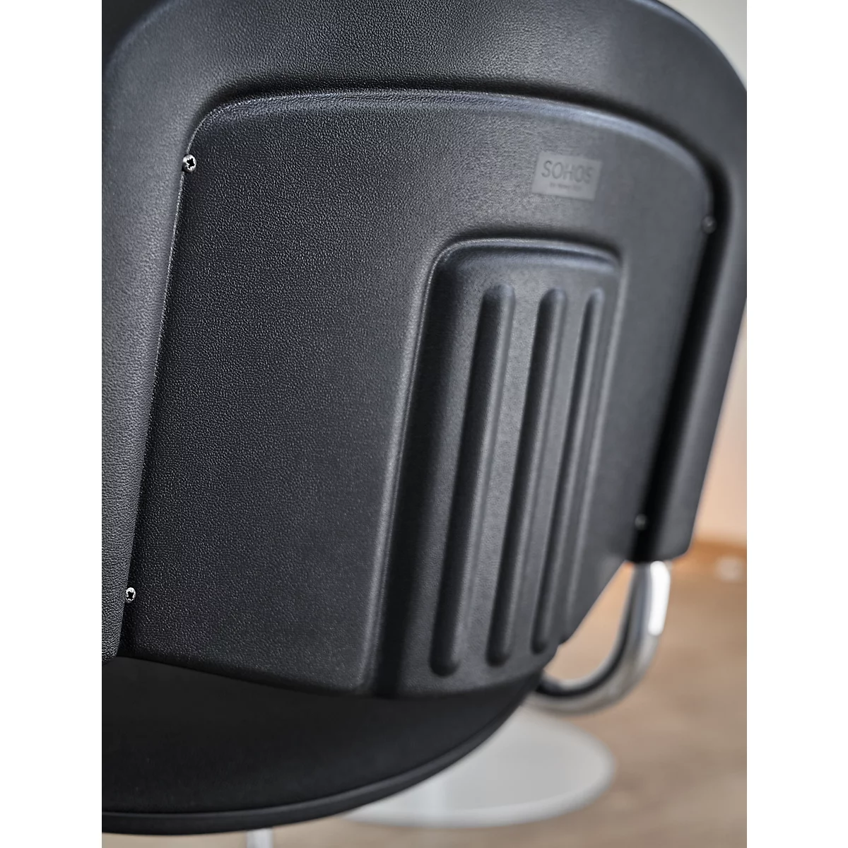 Detailansicht eines schwarzen Stuhlrückens mit einem rechteckigen Design und einem vertikalen Lamellenmuster.