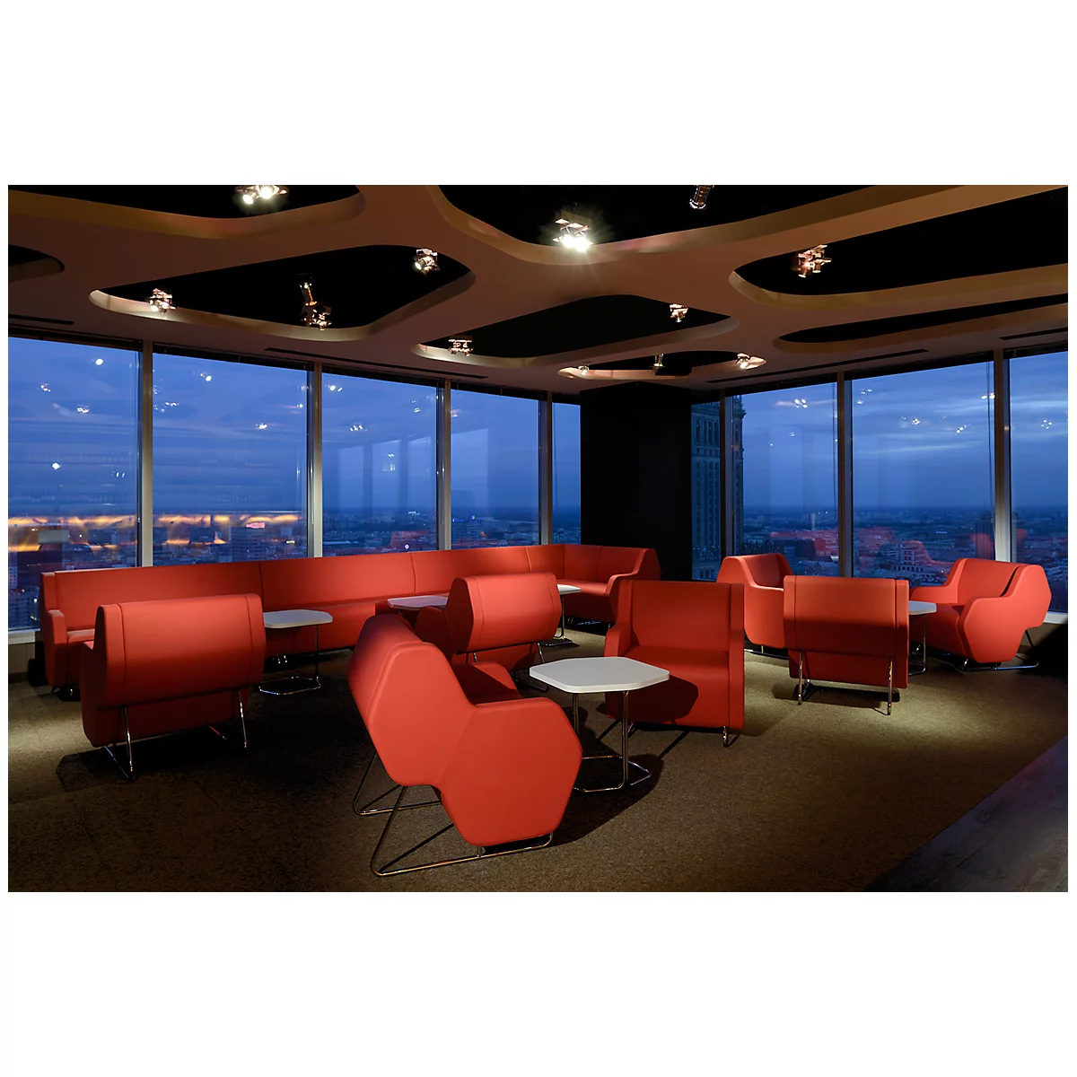 Roter Loungeraum mit Blick auf die Stadt in der Dämmerung, Panoramafenster, bequeme Sitzgelegenheiten.