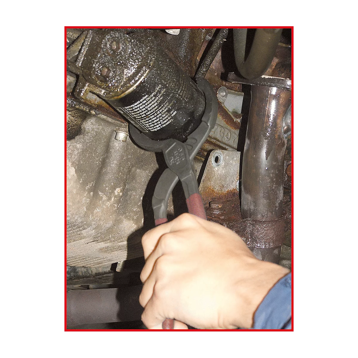 Eine Hand benutzt Zangen, um einen Ölfilter zu entfernen. Der Filter und die Umgebung sind mit Öl bedeckt.